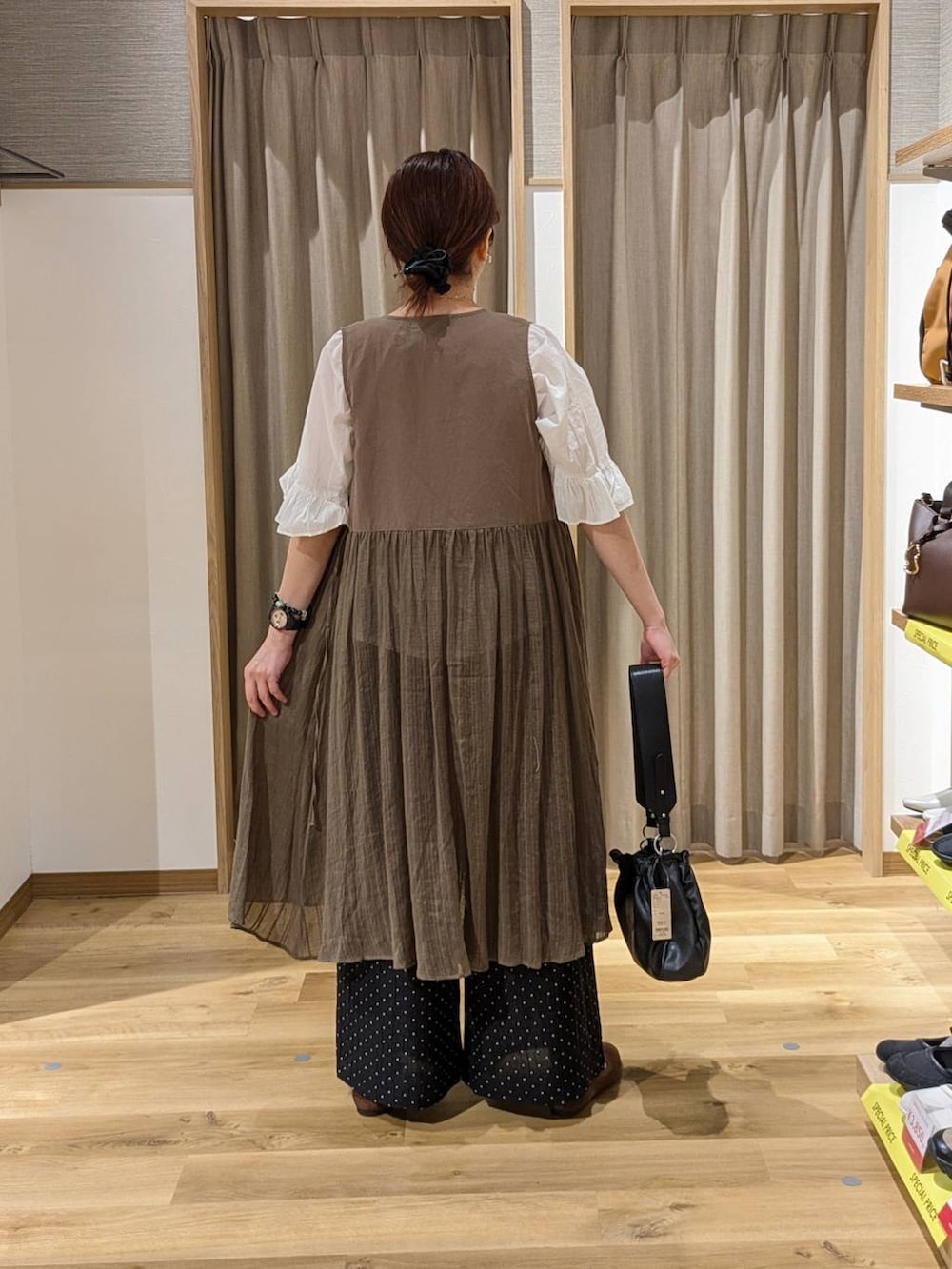 ブラック系のトートバッグ、ブラウン系のパンプス、ホワイト系のシャツ/ブラウスを着用したレディースの春コーディネートの2枚目の写真