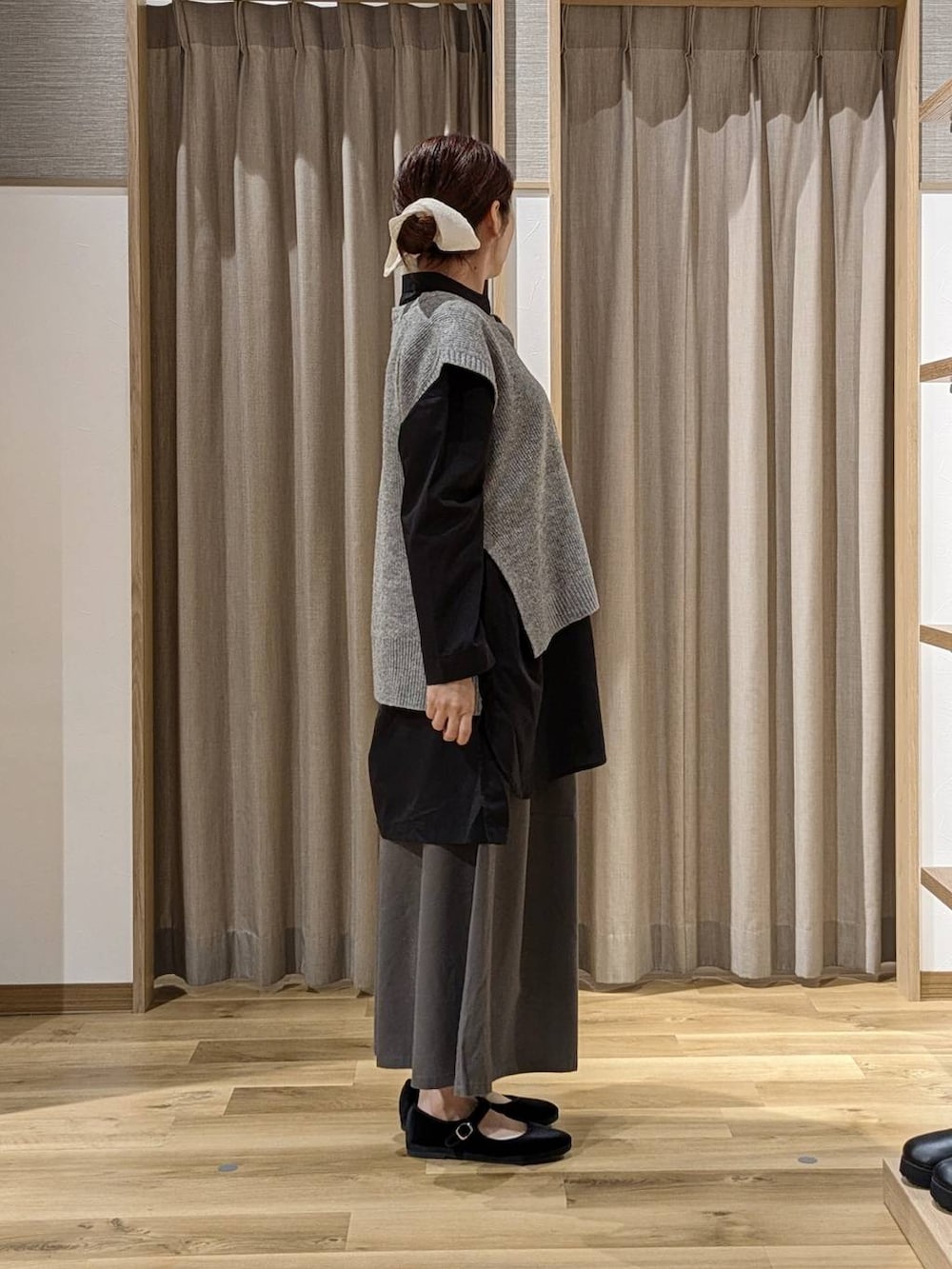 グレー系のチノパンツ、ブラック系のその他シューズ、ブラック系のショルダーバッグを着用したレディースの秋コーディネートの2枚目の写真
