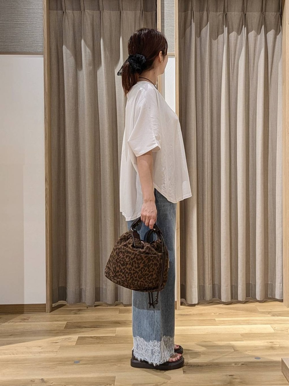 ブルー系のデニムパンツ、ブラウン系のサンダル、その他のTシャツ/カットソーを着用したレディースの夏コーディネートの2枚目の写真