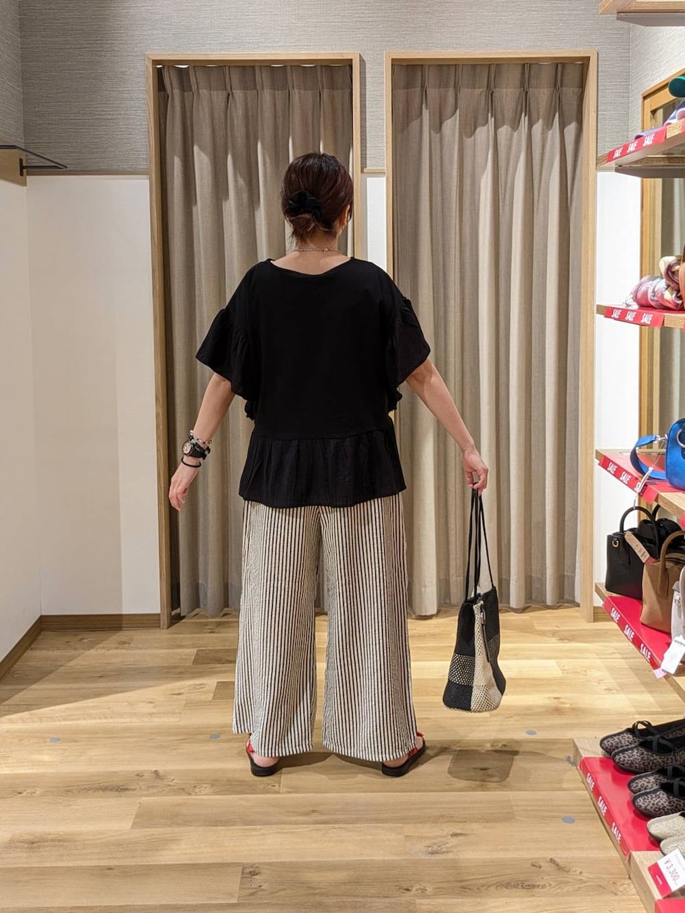 ブラック系のトートバッグ、レッド系のサンダル、その他のその他パンツを着用したレディースの夏コーディネートの2枚目の写真