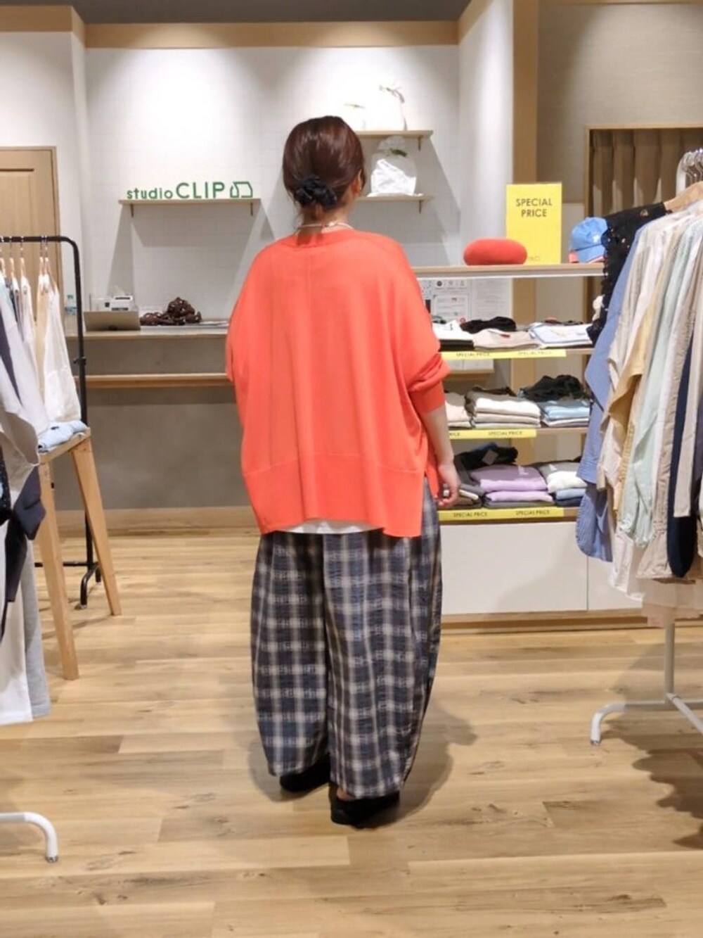 オレンジ系のカーディガン/ボレロ、グリーン系のサンダル、ホワイト系のTシャツ/カットソーを着用したレディースの春コーディネートの2枚目の写真