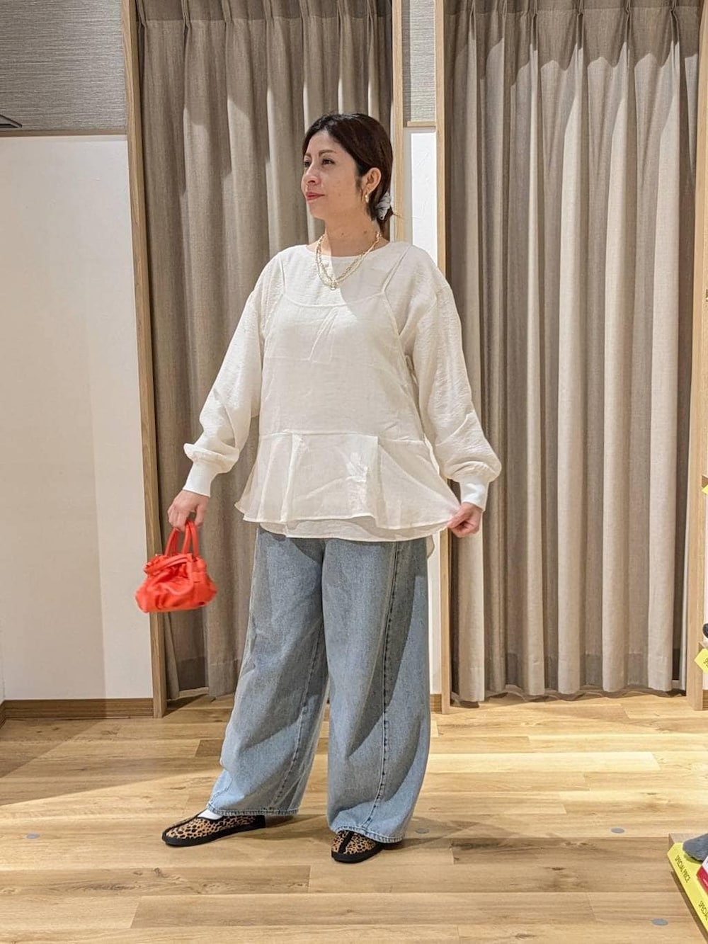 ホワイト系のキャミソール、ブルー系のデニムパンツ、その他のスニーカーを着用したレディースの冬コーディネートの2枚目の写真