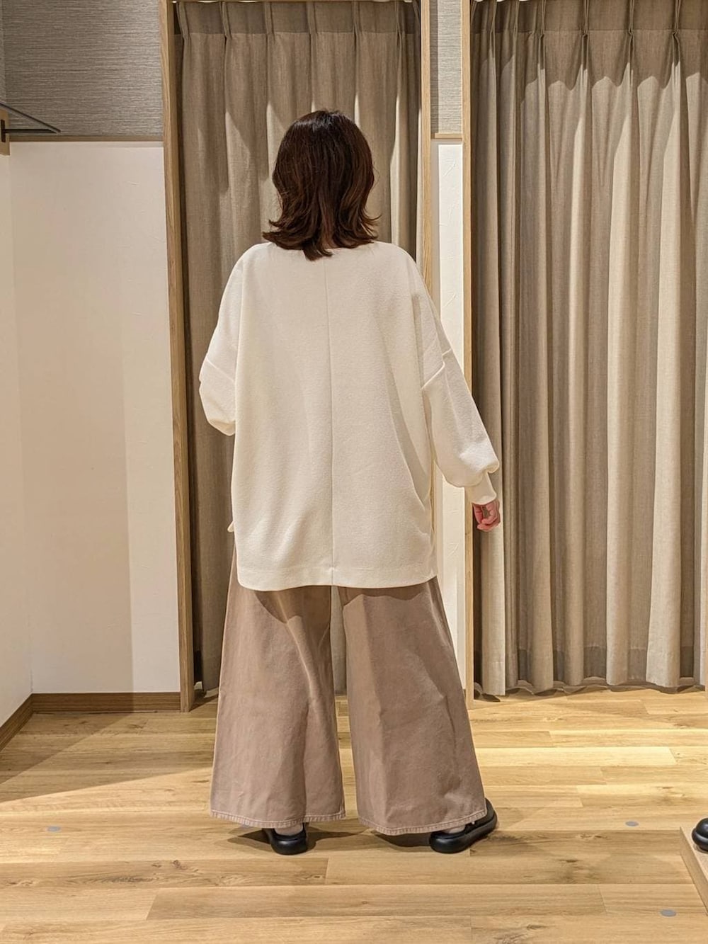 ブラック系のサンダル、ベージュ系のデニムパンツ、ブラック系のショルダーバッグを着用したレディースの冬コーディネートの3枚目の写真