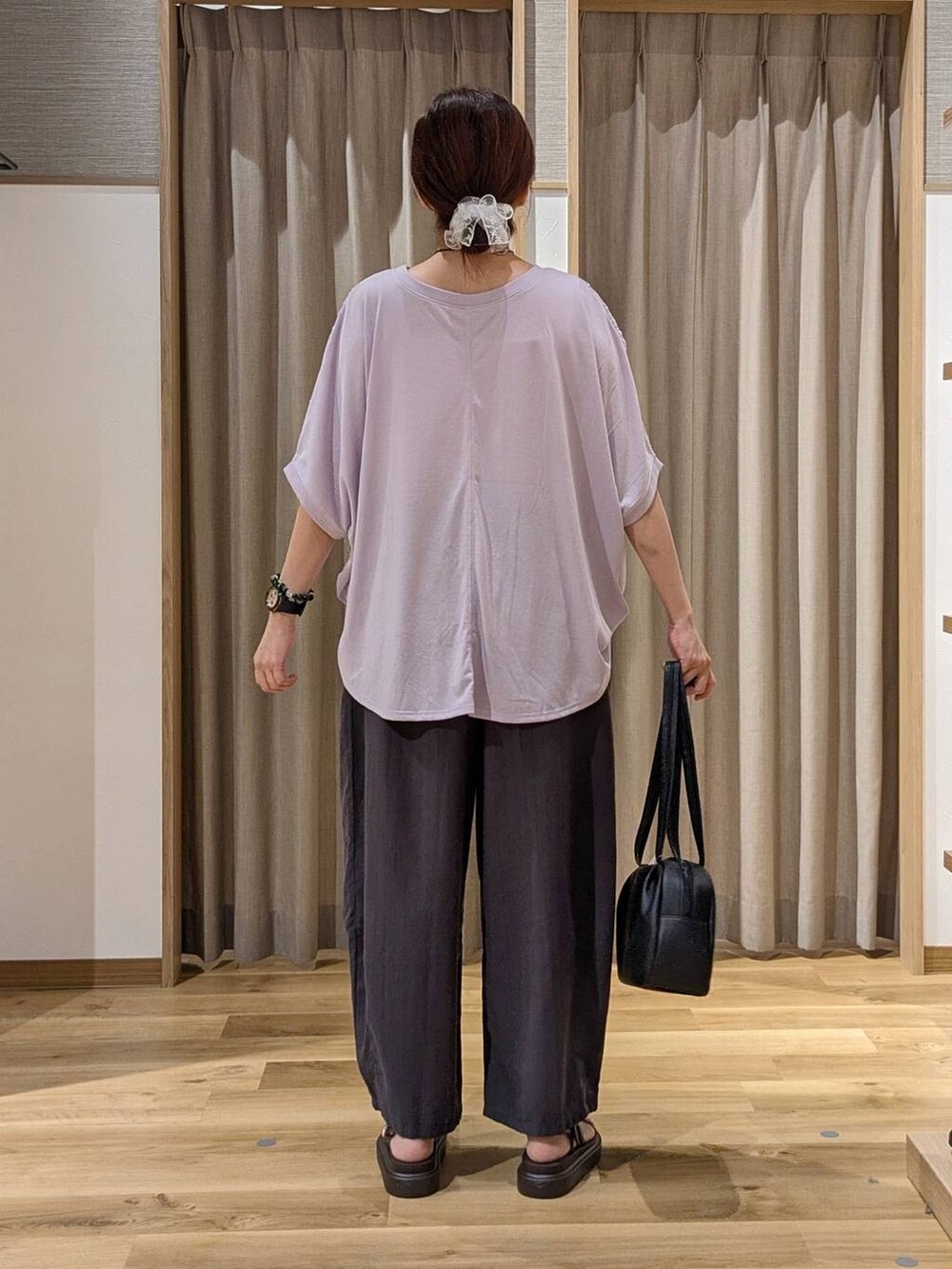 ブラック系のショルダーバッグ、パープル系のTシャツ/カットソー、ブラウン系のサンダルを着用したレディースの夏コーディネートの4枚目の写真