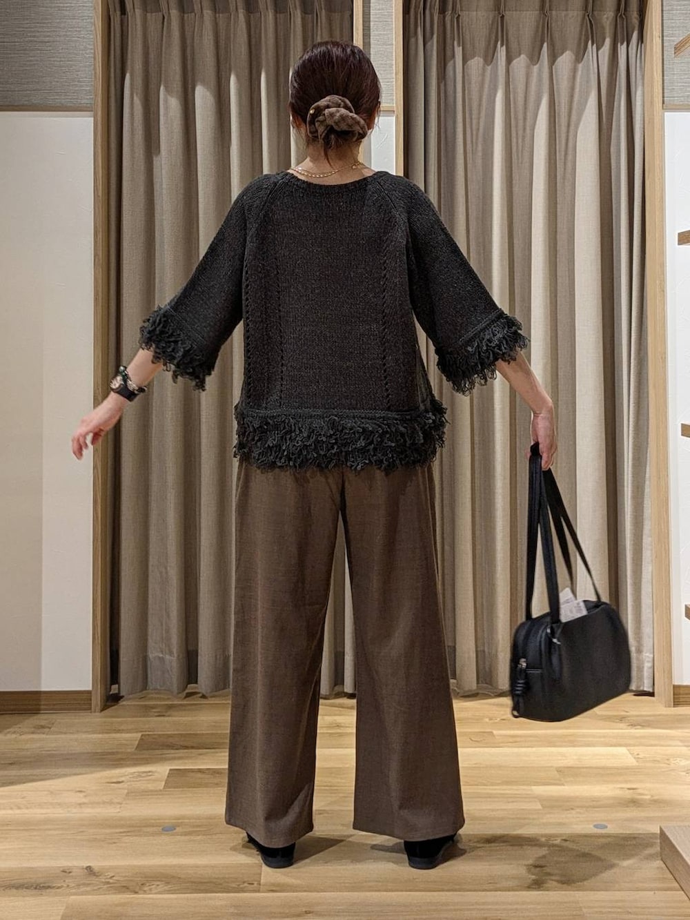 ブラック系のショルダーバッグ、ブラック系のその他シューズ、グレー系のニット/セーターを着用したレディースの秋コーディネートの3枚目の写真