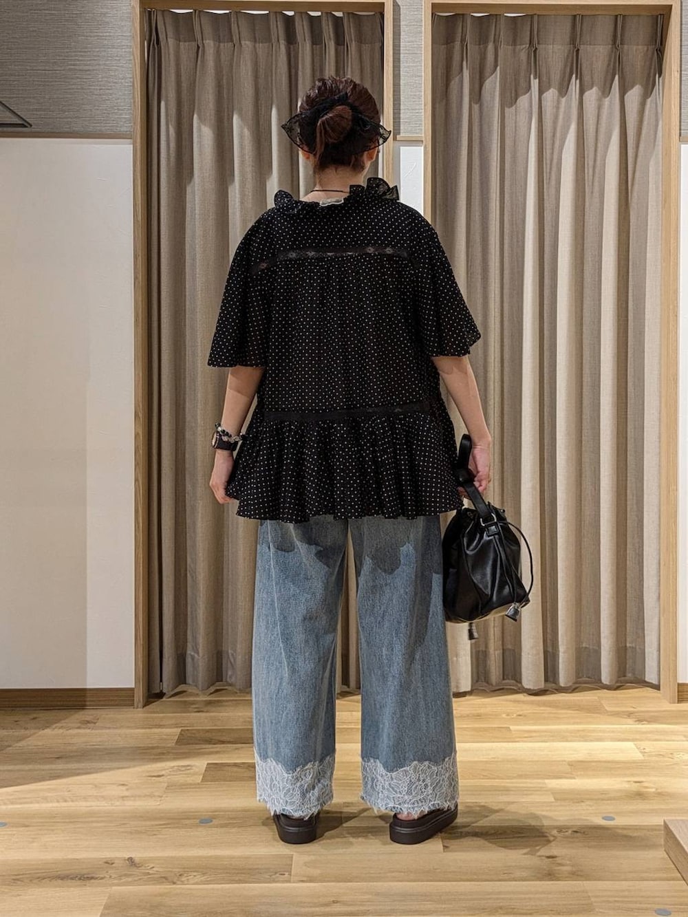 ブルー系のデニムパンツ、ベージュ系のサンダル、ブラック系のトートバッグを着用したレディースの夏コーディネートの4枚目の写真