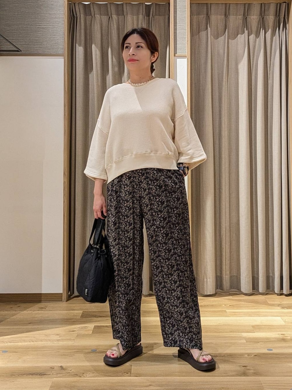 ベージュ系のTシャツ/カットソー、ベージュ系のサンダル、グリーン系のデニムパンツを着用したレディースの夏コーディネートの4枚目の写真