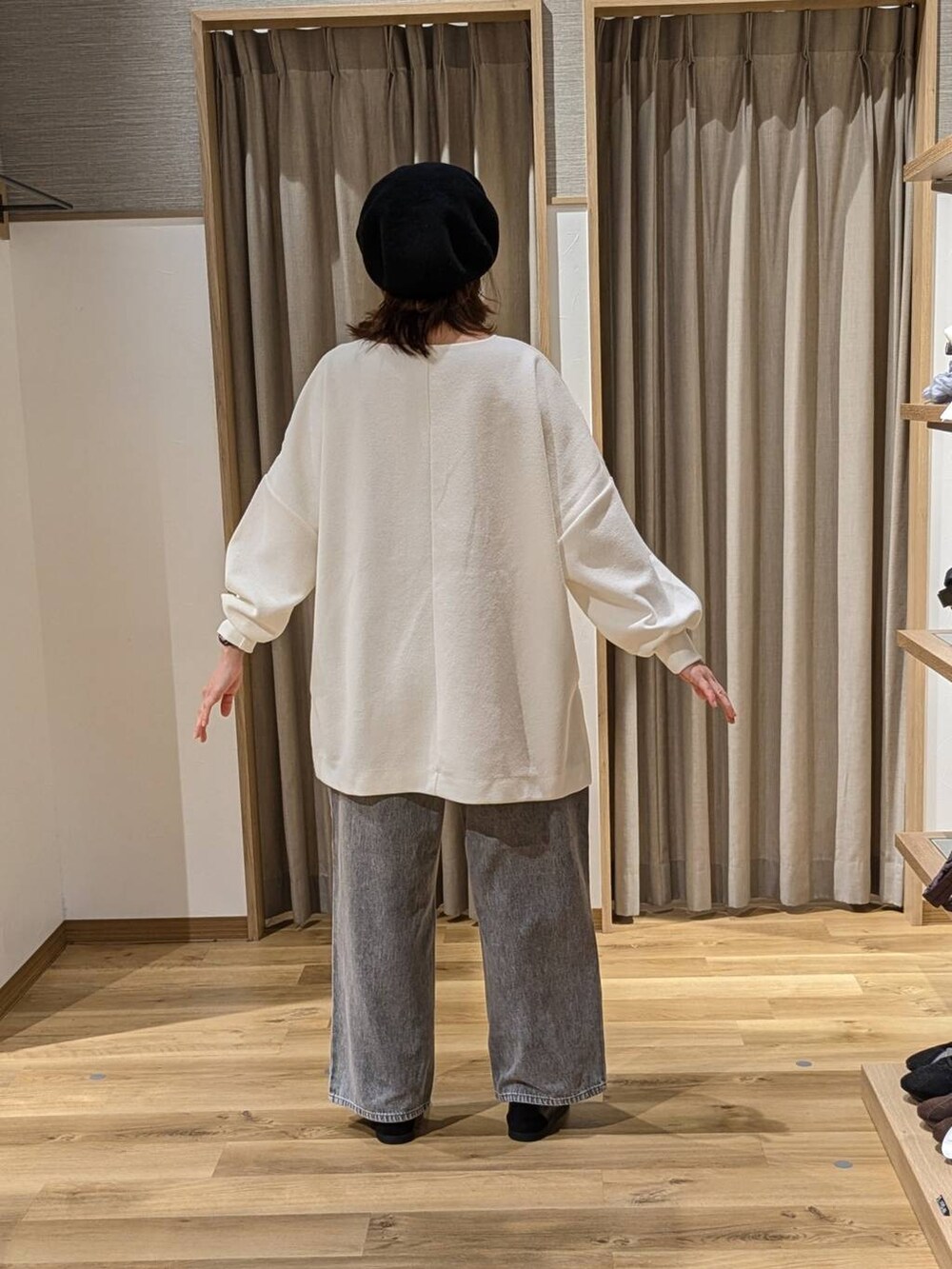 グレー系のデニムパンツ、ブラウン系のショルダーバッグ、ブラック系のスニーカーを着用したレディースの冬コーディネートの2枚目の写真