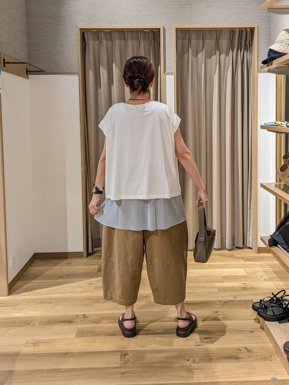 ホワイト系のTシャツ/カットソー、ブラウン系のサンダル、ブラウン系のショルダーバッグを着用したレディースの夏コーディネートの2枚目の写真