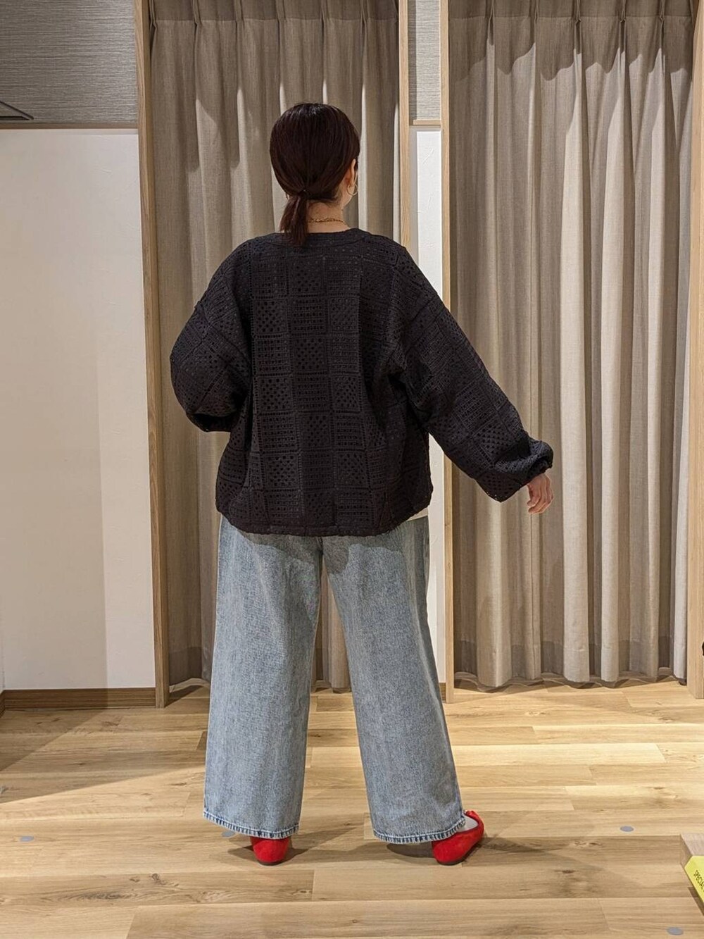 レッド系のパンプス、ブルー系のデニムパンツ、グレー系のブルゾンを着用したレディースの冬コーディネートの2枚目の写真