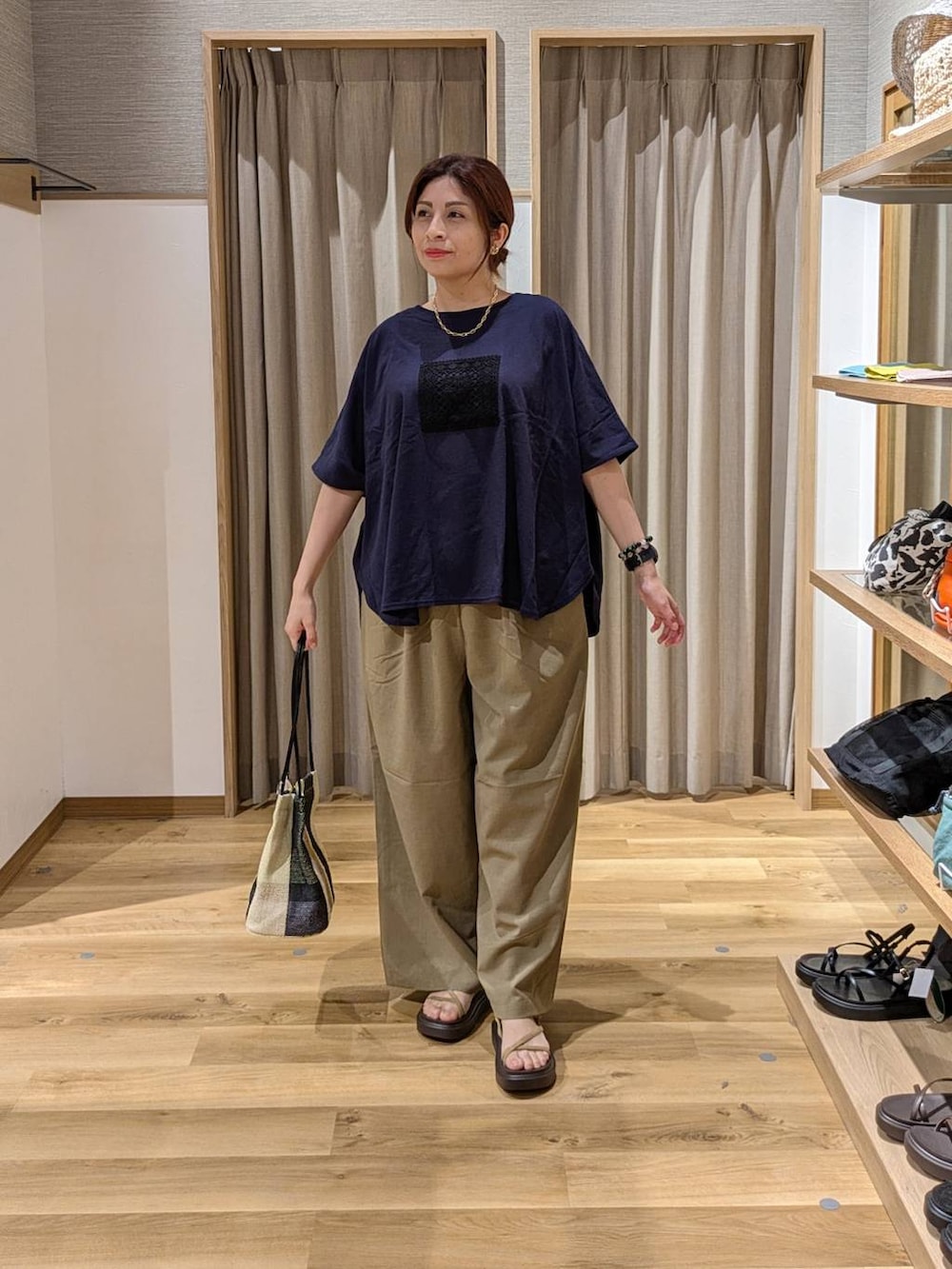 イエロー系のトートバッグ、ベージュ系のサンダル、ベージュ系のその他パンツを着用したレディースの夏コーディネートの3枚目の写真