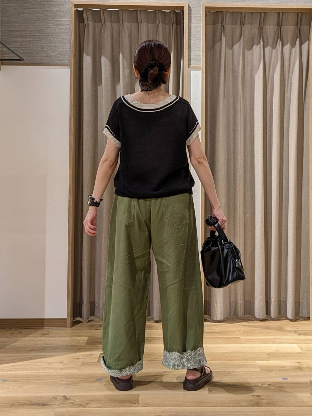 グリーン系のデニムパンツ、ブラック系のニット/セーター、ブラウン系のサンダルを着用したレディースの夏コーディネートの3枚目の写真