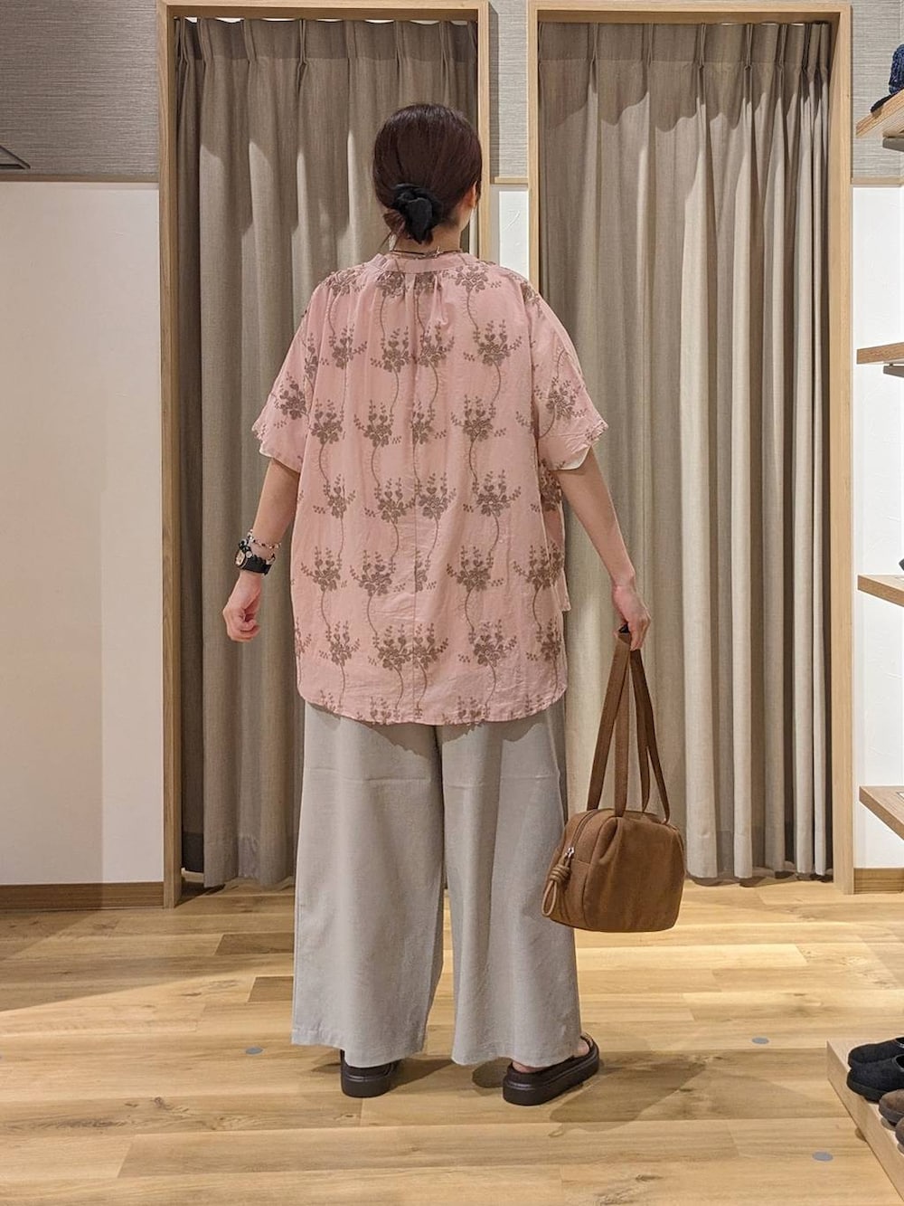 ブラウン系のショルダーバッグ、ピンク系のシャツ/ブラウス、ブラウン系のサンダルを着用したレディースの夏コーディネートの3枚目の写真