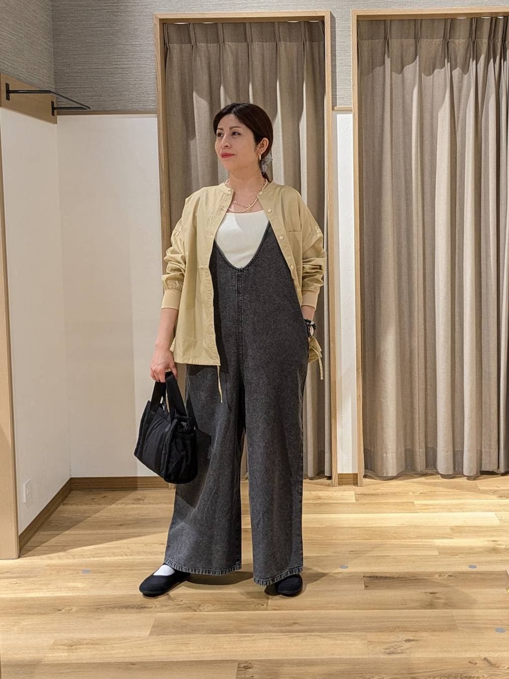 ブラック系のサロペット/オーバーオール、ベージュ系のシャツ/ブラウス、ブラック系のバレエシューズを着用したレディースの春コーディネートの2枚目の写真