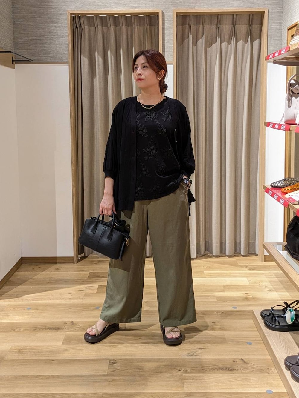 ベージュ系のサンダル、グリーン系のその他パンツ、ブラック系のTシャツ/カットソーを着用したレディースの夏コーディネートの3枚目の写真