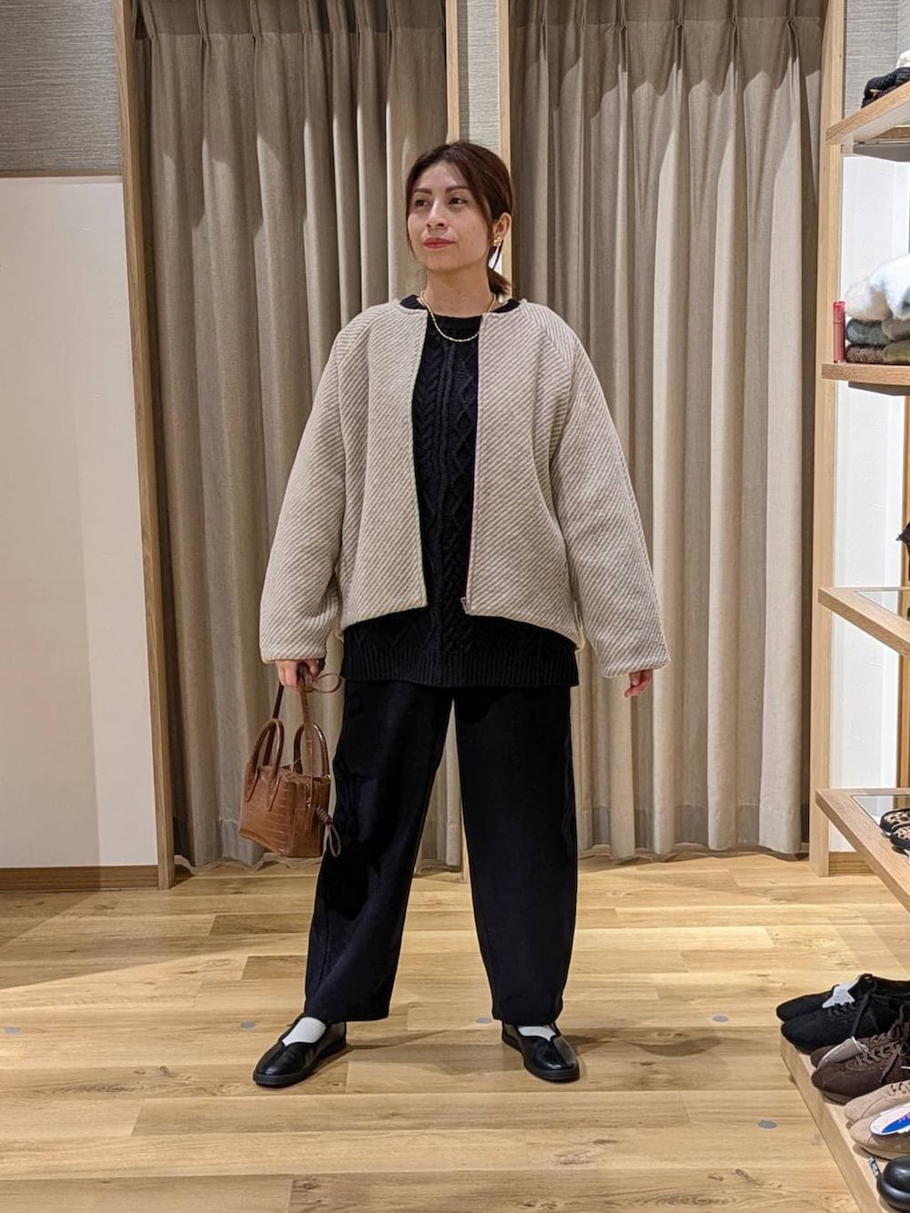 ブルー系のその他パンツ、ベージュ系のノーカラーコート、ブルー系のニット/セーターを着用したレディースの冬コーディネートの2枚目の写真