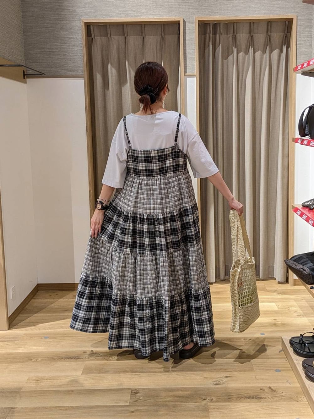 ベージュ系のトートバッグ、ブラウン系のサンダル、ブルー系のTシャツ/カットソーを着用したレディースの夏コーディネートの2枚目の写真