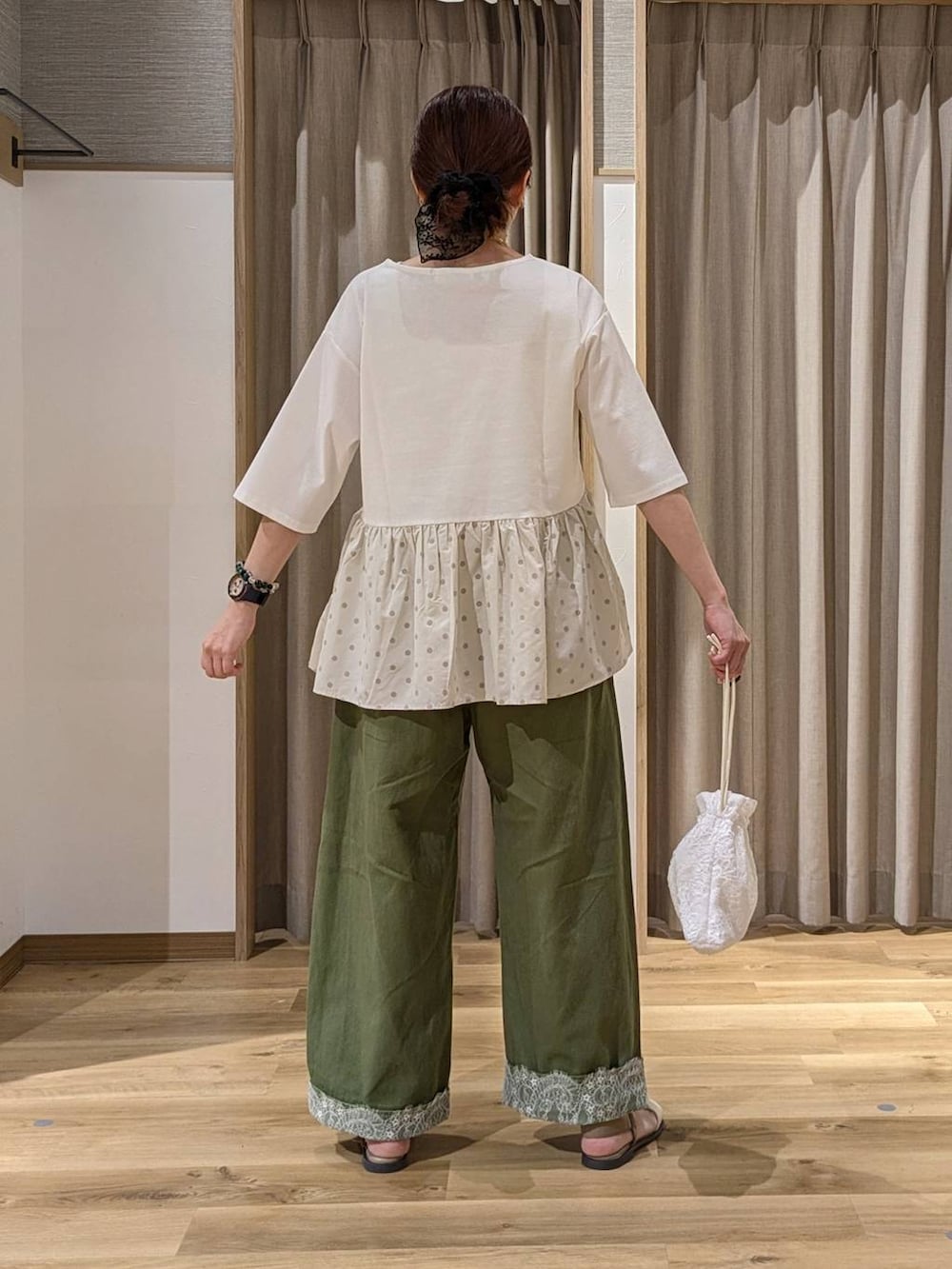 グリーン系のデニムパンツ、ベージュ系のTシャツ/カットソー、ベージュ系のサンダルを着用したレディースの夏コーディネートの2枚目の写真