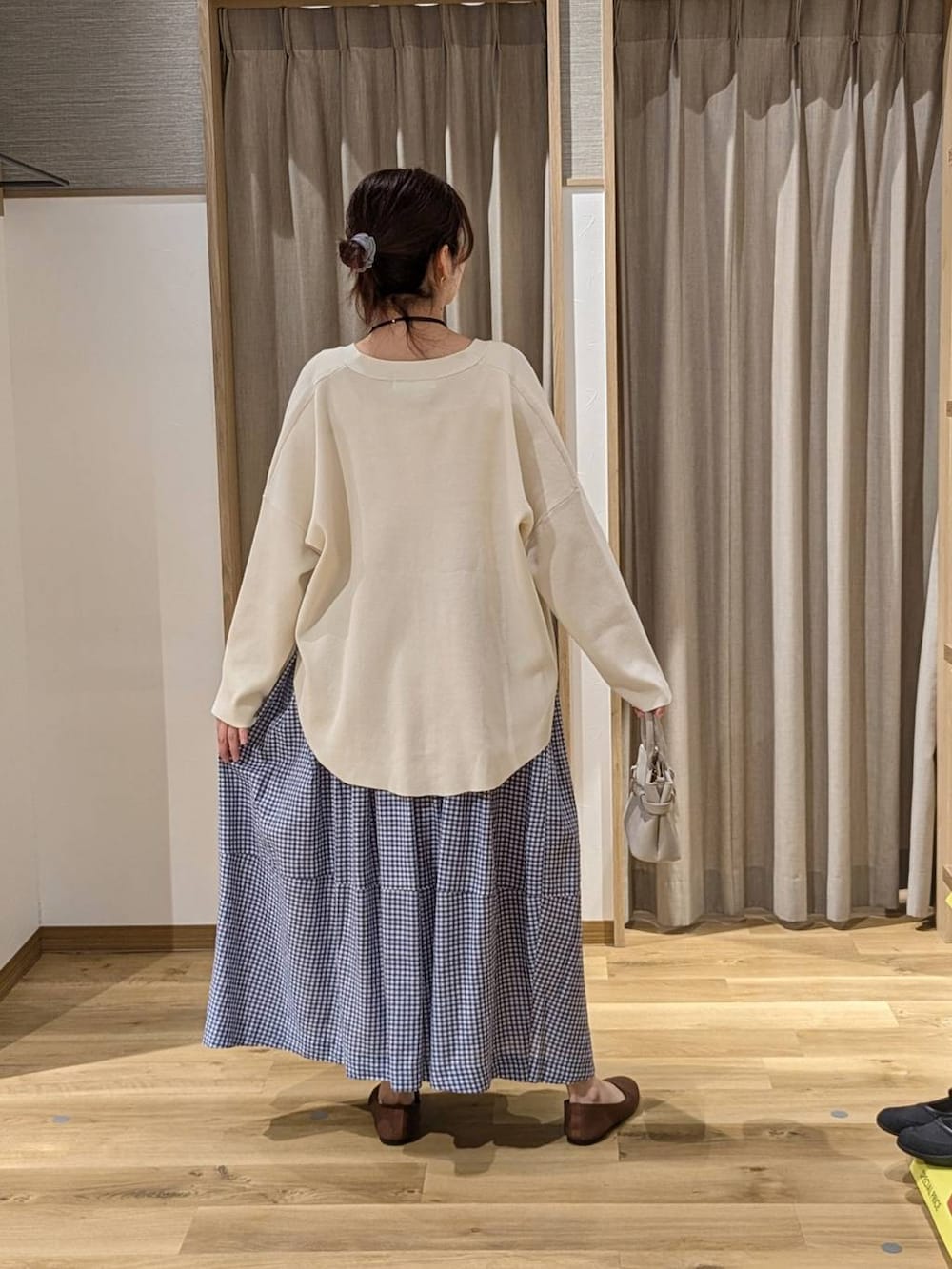 ベージュ系のショルダーバッグ、ブラウン系のパンプス、ベージュ系のタンクトップを着用したレディースの春コーディネートの2枚目の写真