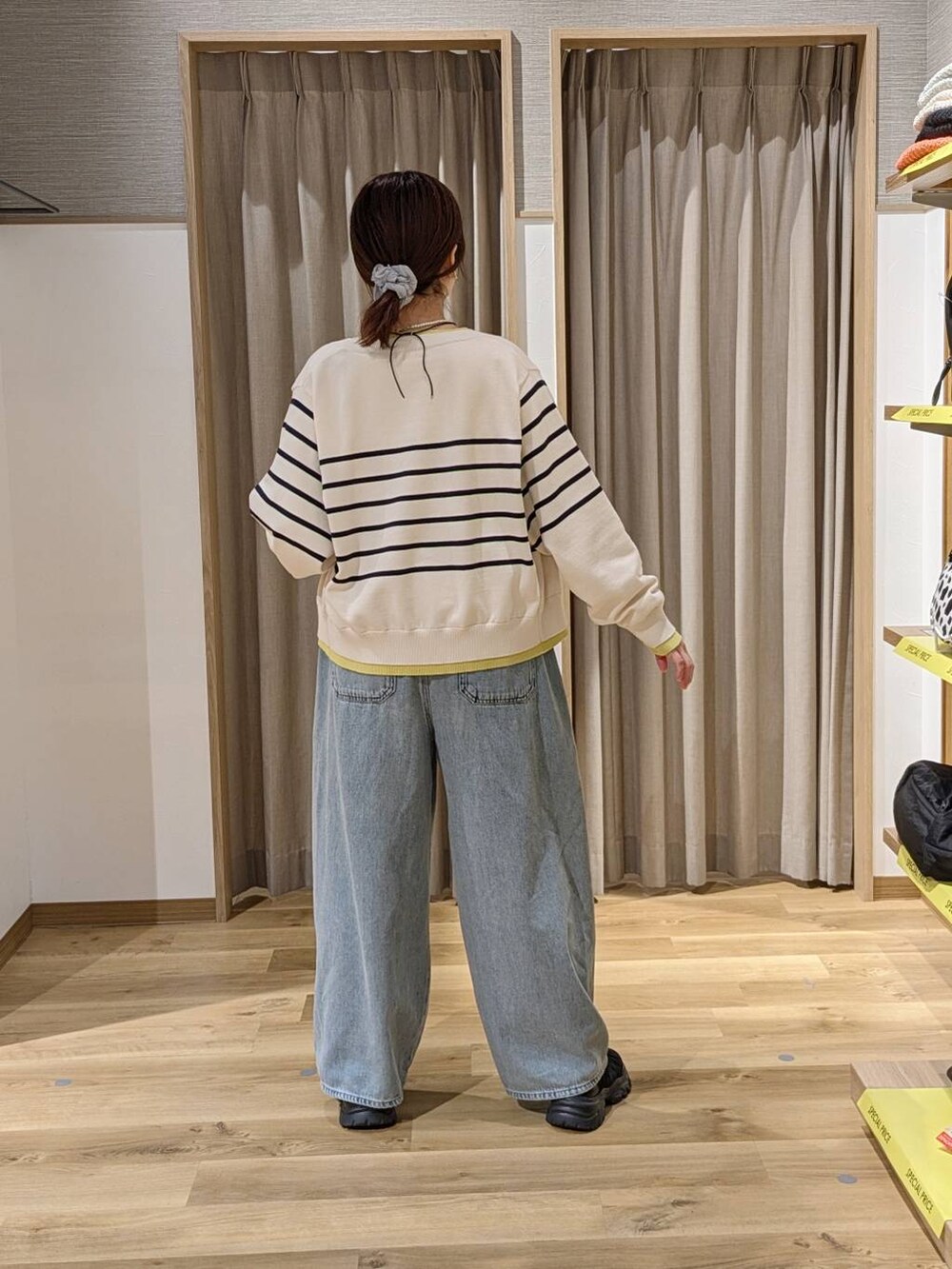 ブルー系のデニムパンツ、ブラック系のスニーカー、ベージュ系のカーディガン/ボレロを着用したレディースの春コーディネートの2枚目の写真
