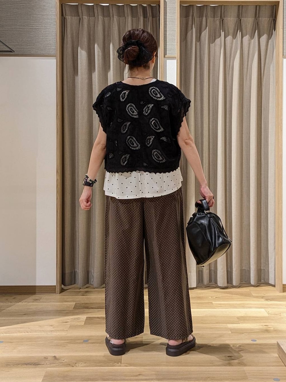 ブラック系のベスト、その他のTシャツ/カットソー、ベージュ系のサンダルを着用したレディースの夏コーディネートの3枚目の写真