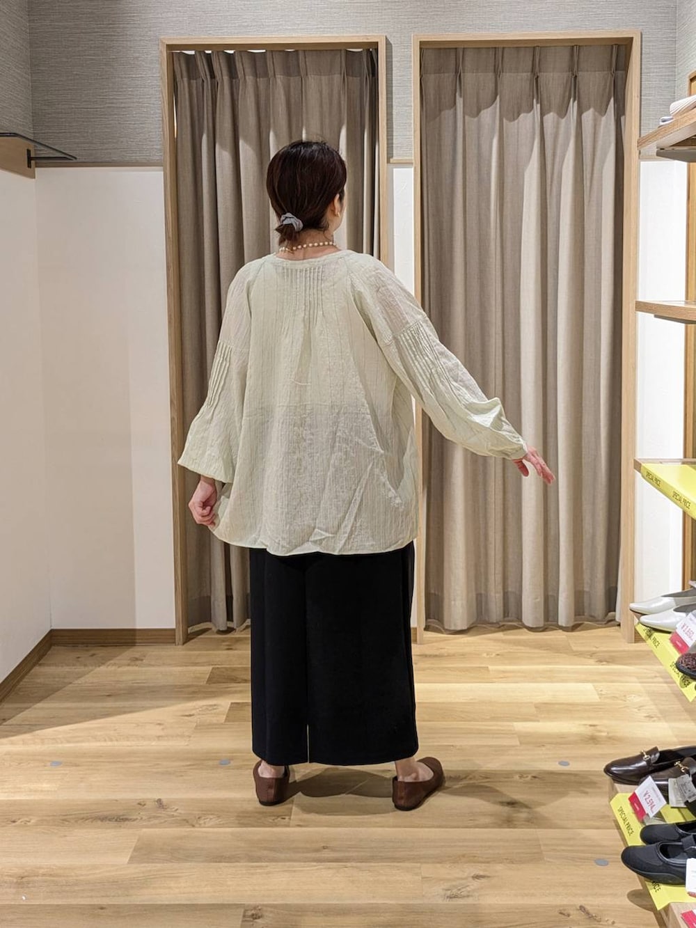 ブラック系のトートバッグ、ブラウン系のパンプス、ブラック系のスカートを着用したレディースの春コーディネートの2枚目の写真