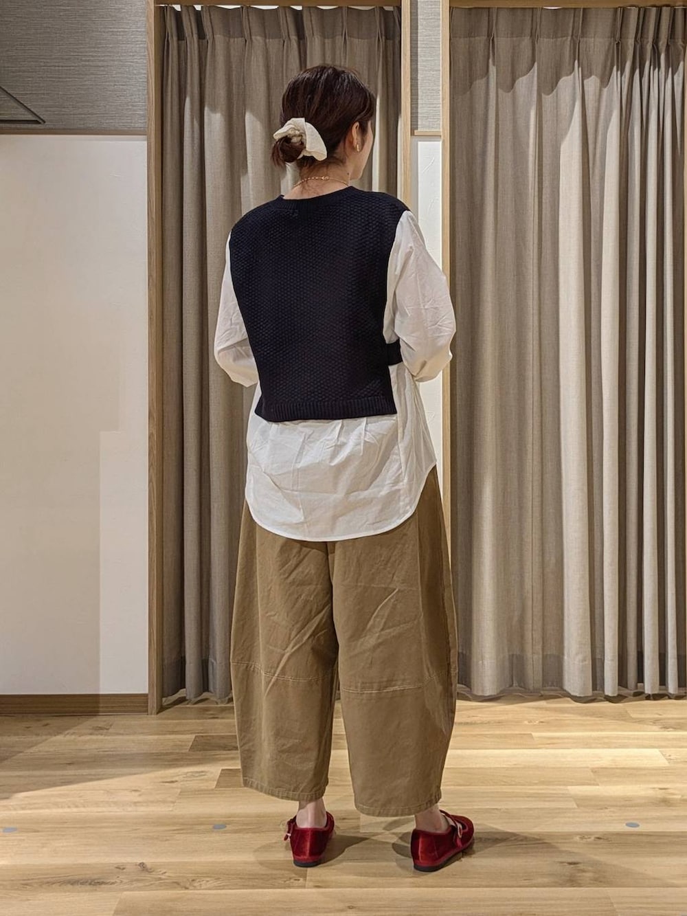 レッド系のその他シューズ、ベージュ系のその他パンツ、ブラック系のショルダーバッグを着用したレディースの秋コーディネートの2枚目の写真