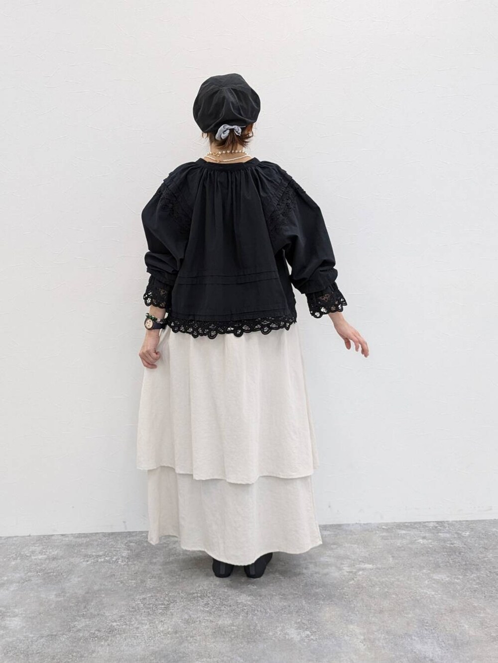 ベージュ系のタンクトップ、ホワイト系のスカート、ブラック系のシャツ/ブラウスを着用したレディースの春コーディネートの2枚目の写真