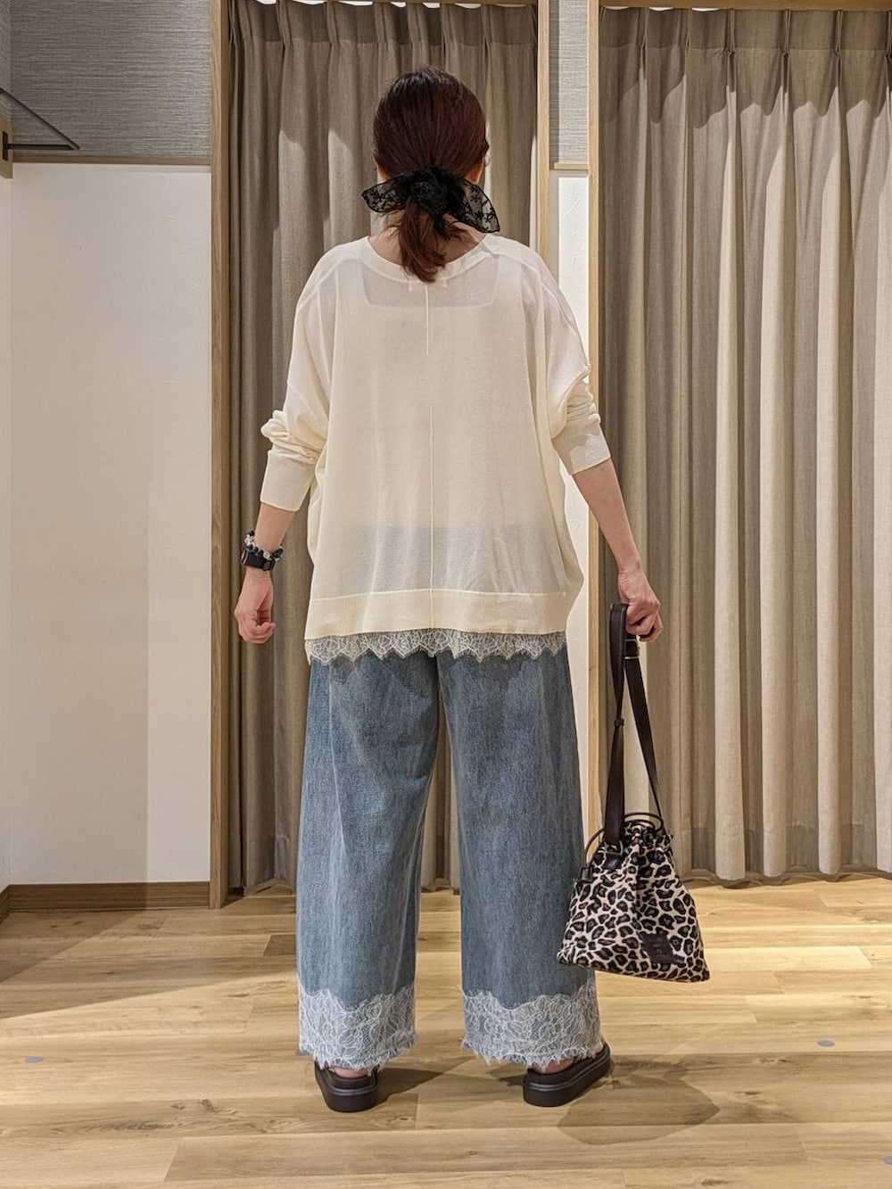 ブルー系のデニムパンツ、ホワイト系のカーディガン/ボレロ、ベージュ系のサンダルを着用したレディースの夏コーディネートの3枚目の写真