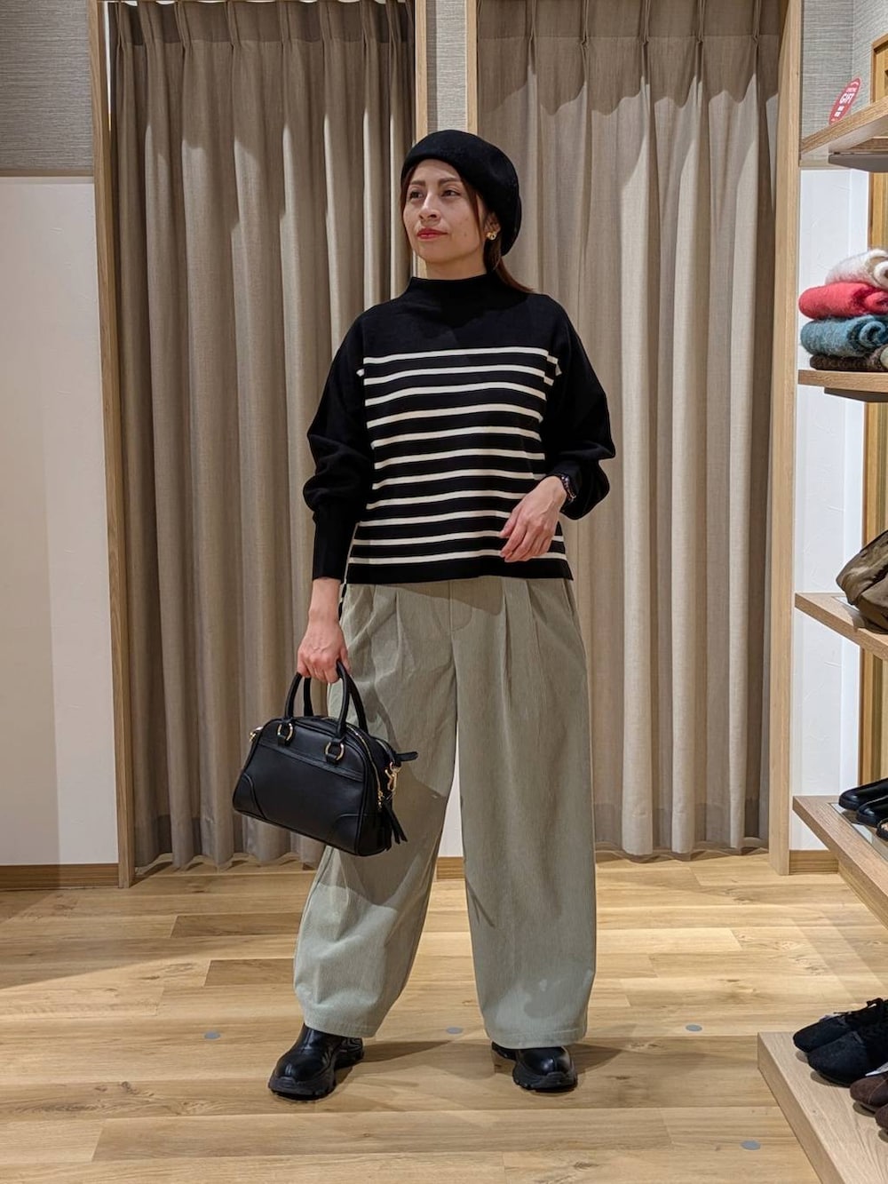 ブラック系のブーツ、ブラック系のショルダーバッグ、グリーン系のその他パンツを着用したレディースの冬コーディネートの2枚目の写真