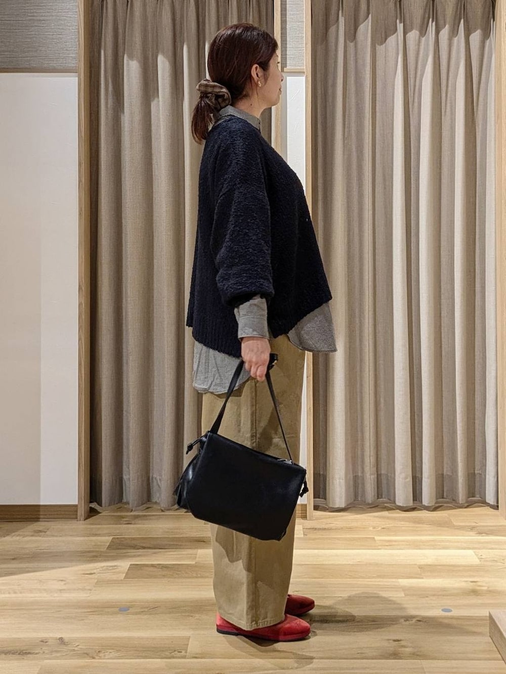 レッド系のその他シューズ、ブルー系のニット/セーター、ベージュ系のその他パンツを着用したレディースの秋コーディネートの2枚目の写真