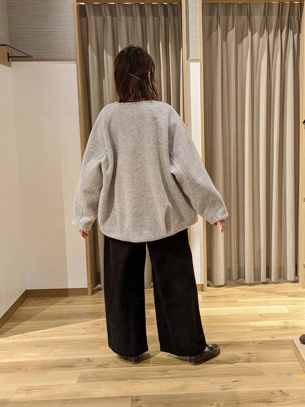 グレー系のノーカラーコート、ブラック系のTシャツ/カットソー、ブラック系のその他パンツを着用したレディースの冬コーディネートの2枚目の写真