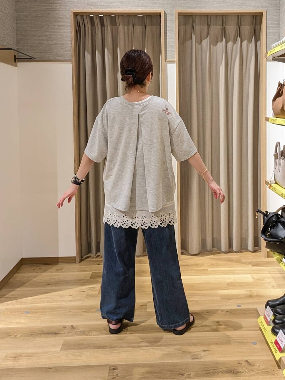 ブラウン系のサンダル、ブルー系のデニムパンツ、ブラウン系のショルダーバッグを着用したレディースの春コーディネートの2枚目の写真