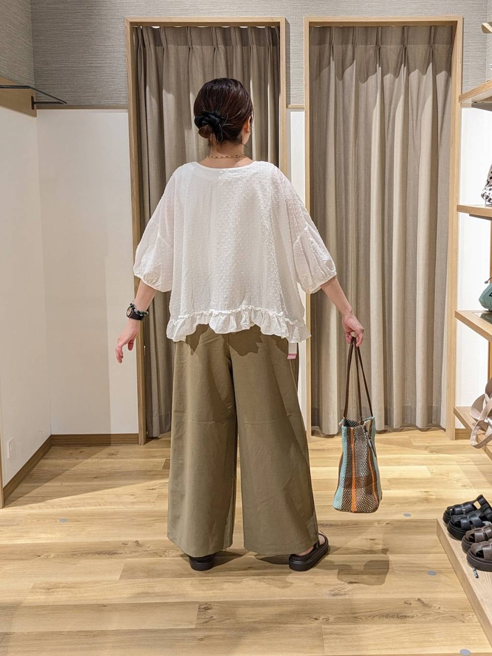ブラウン系のトートバッグ、ブラウン系のサンダル、ベージュ系のその他パンツを着用したレディースの夏コーディネートの2枚目の写真