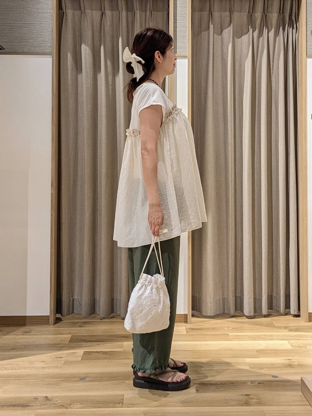 グリーン系のその他パンツ、ベージュ系のサンダル、ホワイト系のTシャツ/カットソーを着用したレディースの夏コーディネートの2枚目の写真