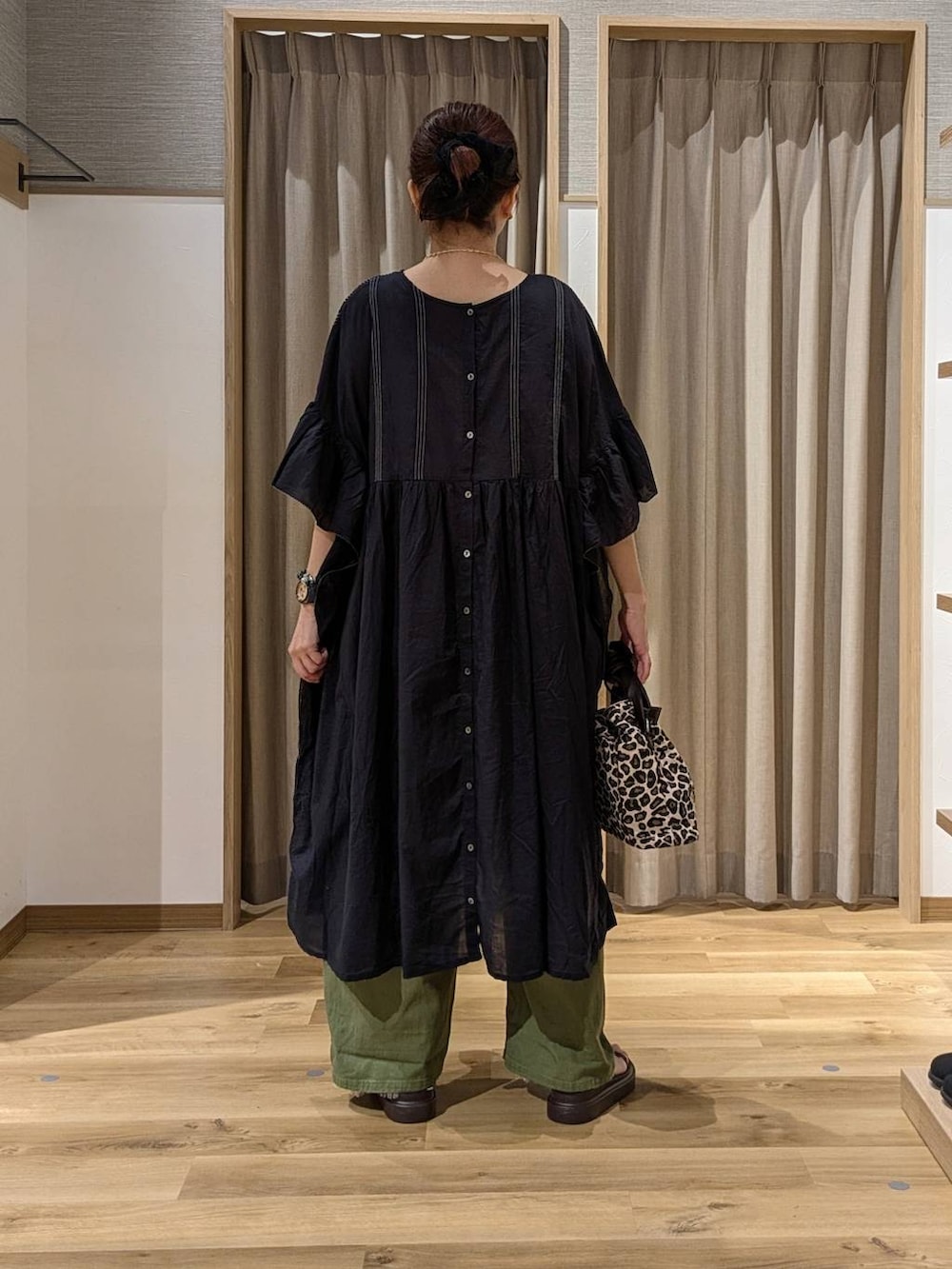 グリーン系のデニムパンツ、ブラウン系のサンダル、ブラック系のワンピースを着用したレディースの夏コーディネートの3枚目の写真