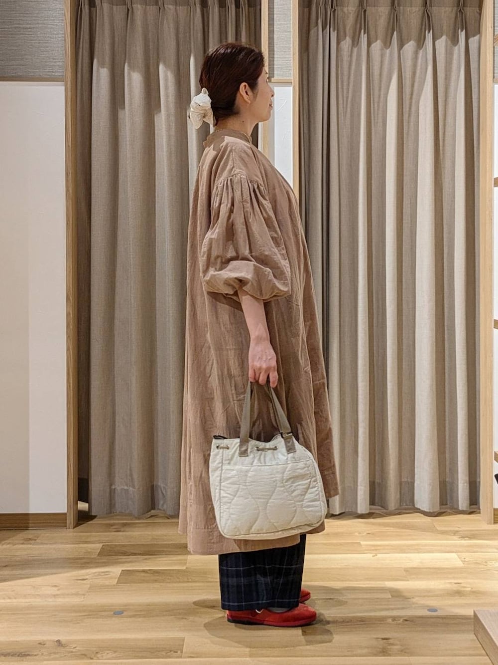 レッド系のその他シューズ、ベージュ系のワンピース、ブラック系のその他パンツを着用したレディースの秋コーディネートの2枚目の写真
