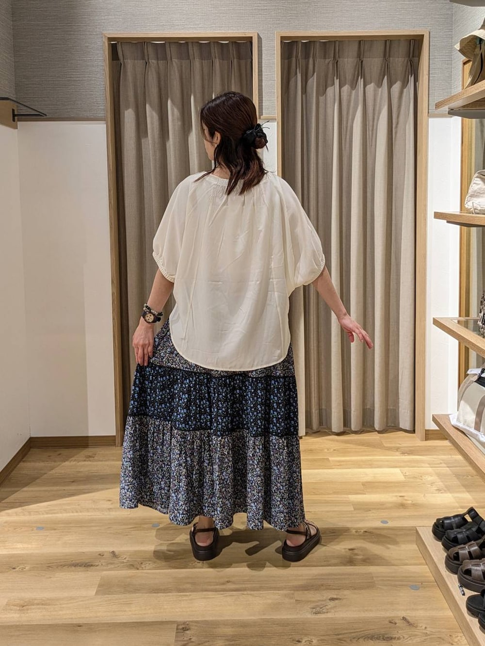 ベージュ系のかごバッグ、ブラウン系のサンダル、ブルー系のスカートを着用したレディースの夏コーディネートの2枚目の写真