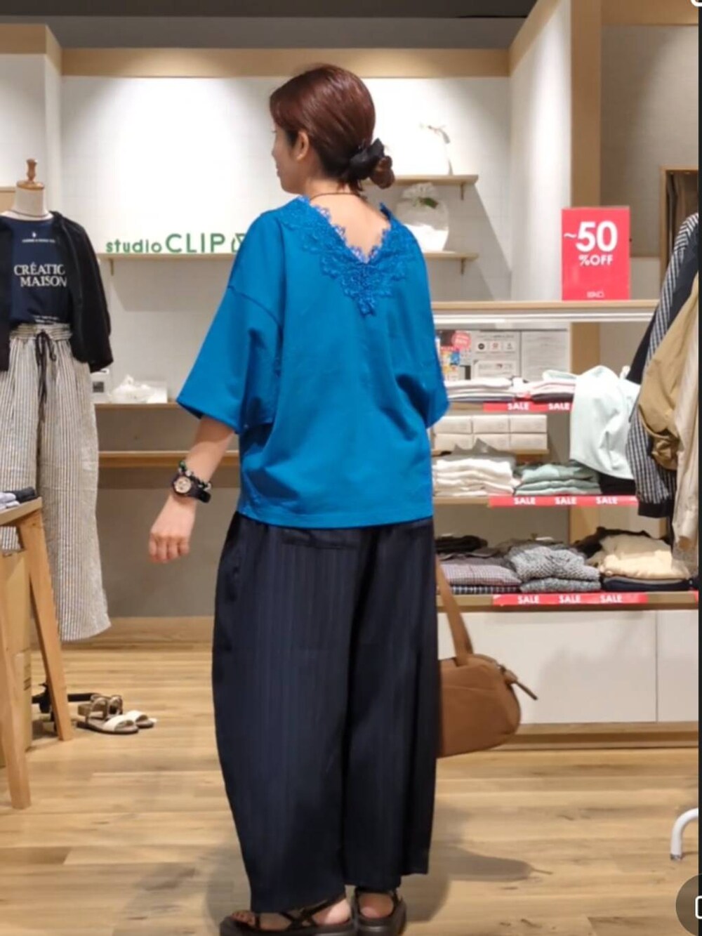 ブラウン系のショルダーバッグ、ブルー系のその他パンツ、ブラウン系のサンダルを着用したレディースの夏コーディネートの3枚目の写真