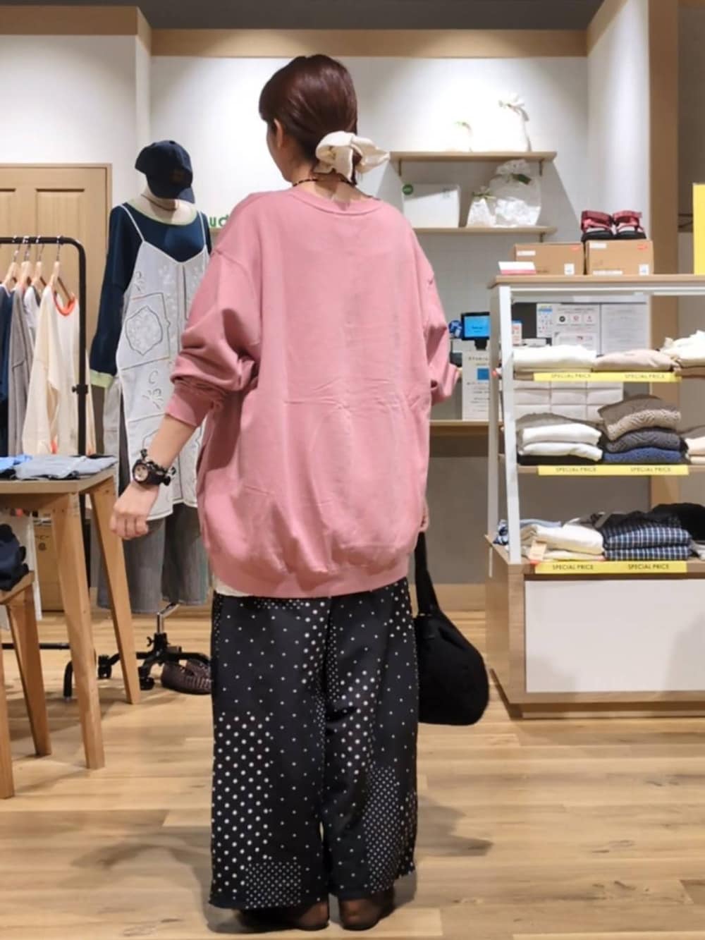 ピンク系のスウェット、ホワイト系のベスト、ブラック系のその他パンツを着用したレディースの秋コーディネートの2枚目の写真
