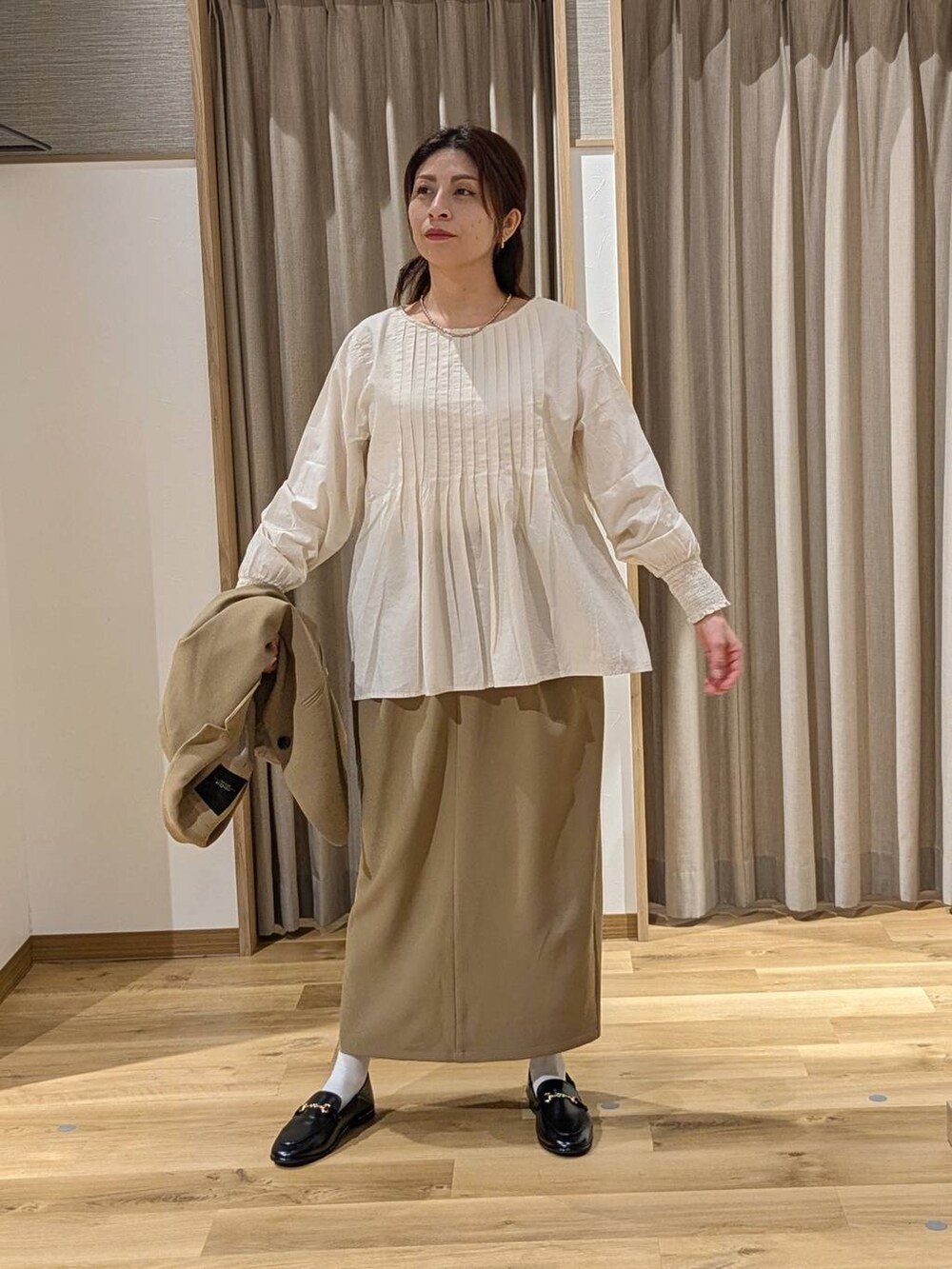 ベージュ系のスカート、ベージュ系のテーラードジャケット、ブラック系のトートバッグを着用したレディースの冬コーディネートの4枚目の写真