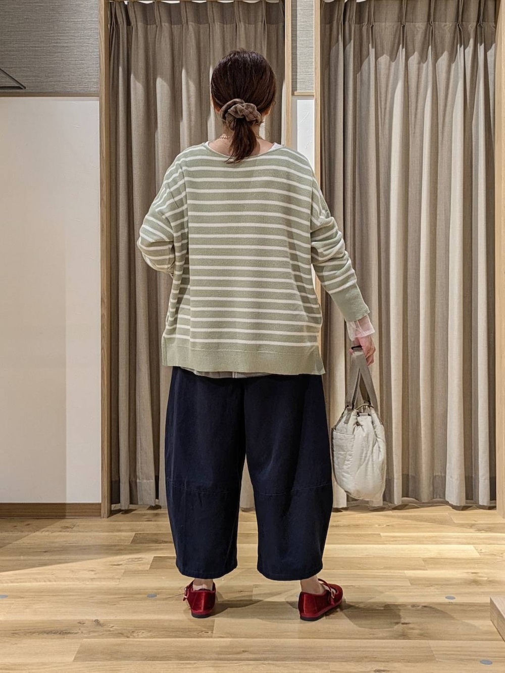 レッド系のその他シューズ、その他のTシャツ/カットソー、グリーン系のニット/セーターを着用したレディースの秋コーディネートの3枚目の写真