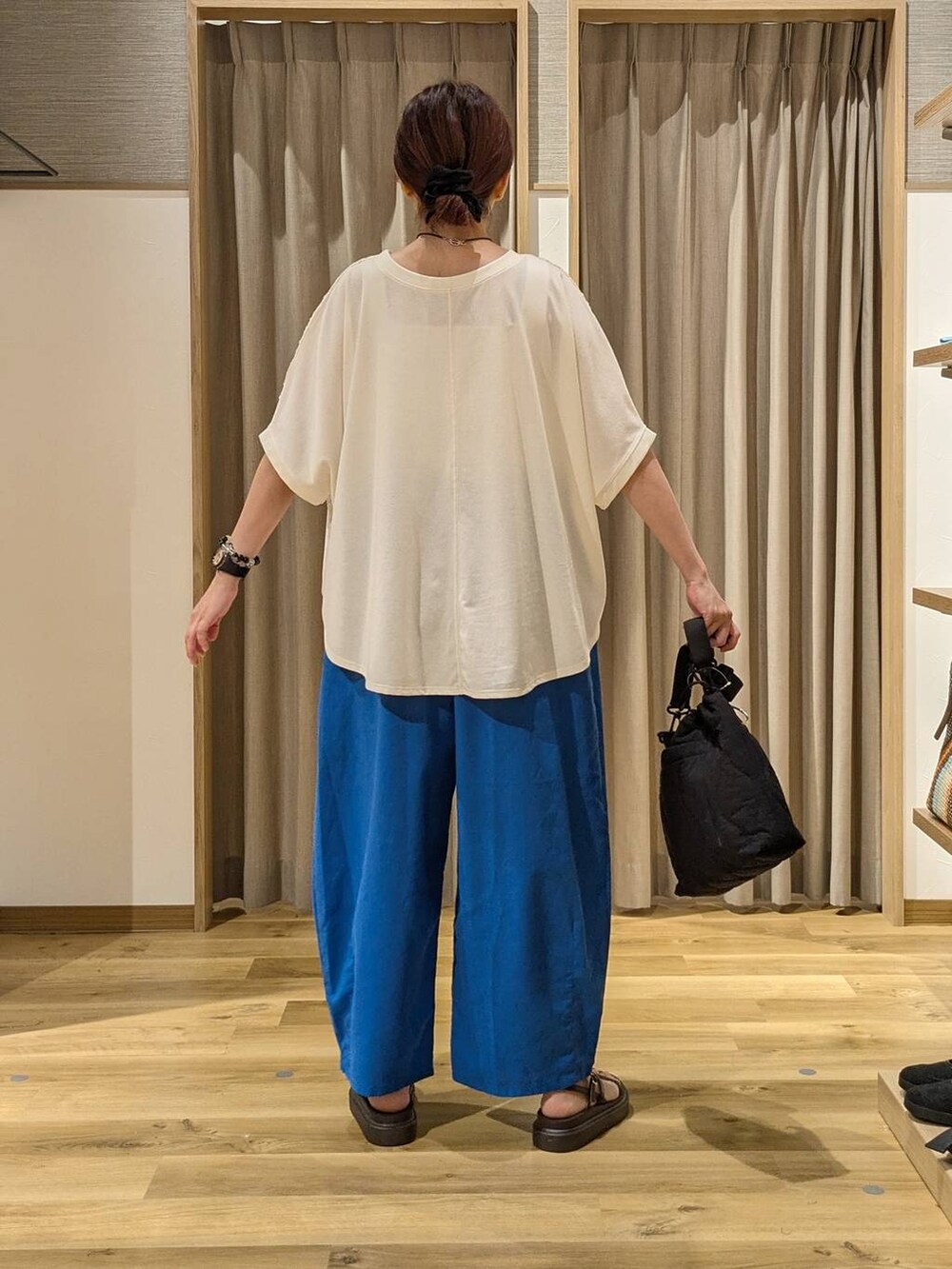 ホワイト系のTシャツ/カットソー、ブラック系のショルダーバッグ、ブラウン系のサンダルを着用したレディースの夏コーディネートの3枚目の写真