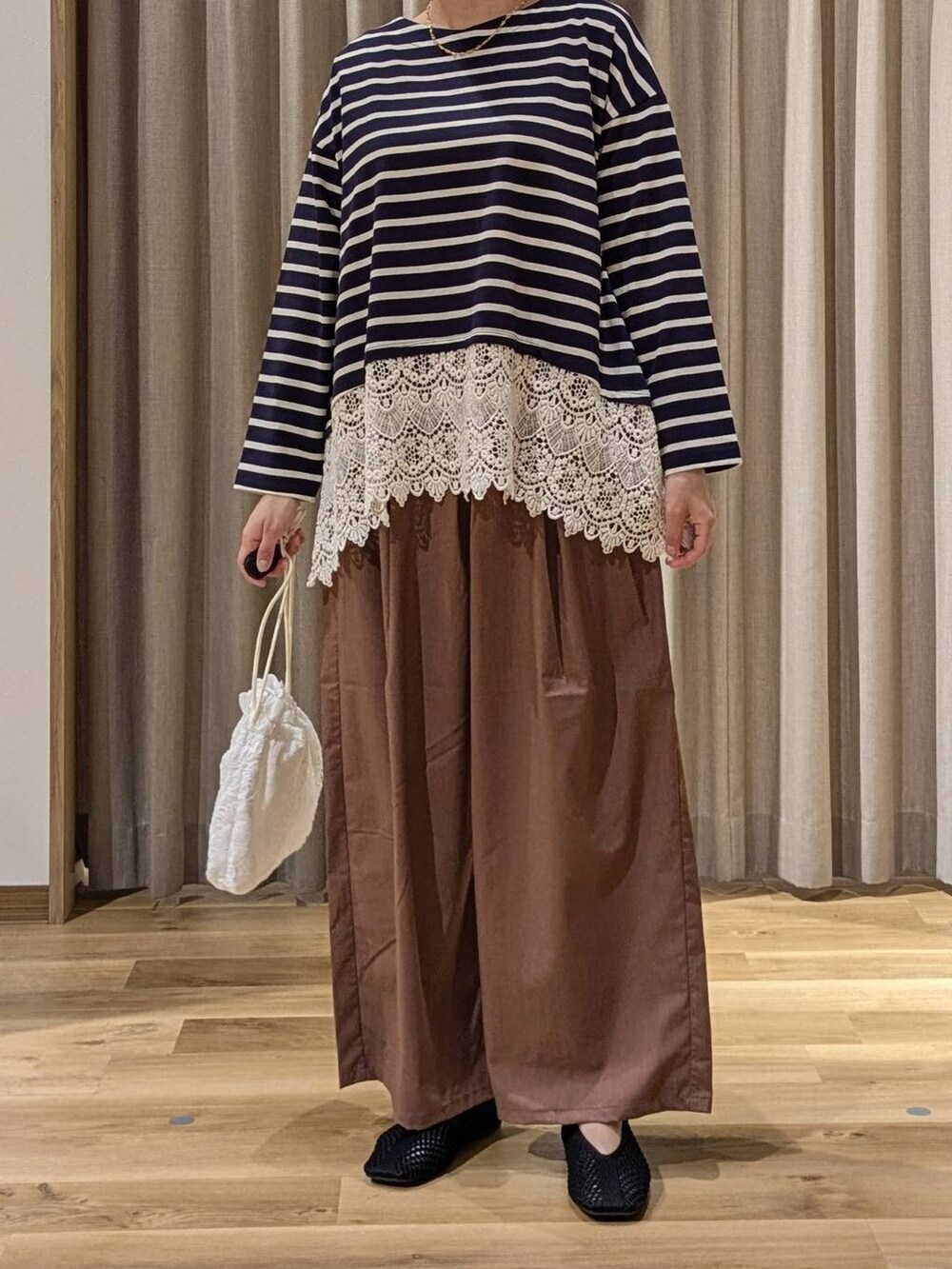 ブルー系のTシャツ/カットソー、ブラウン系のその他パンツ、ブラック系のパンプスを着用したレディースの秋コーディネートの2枚目の写真
