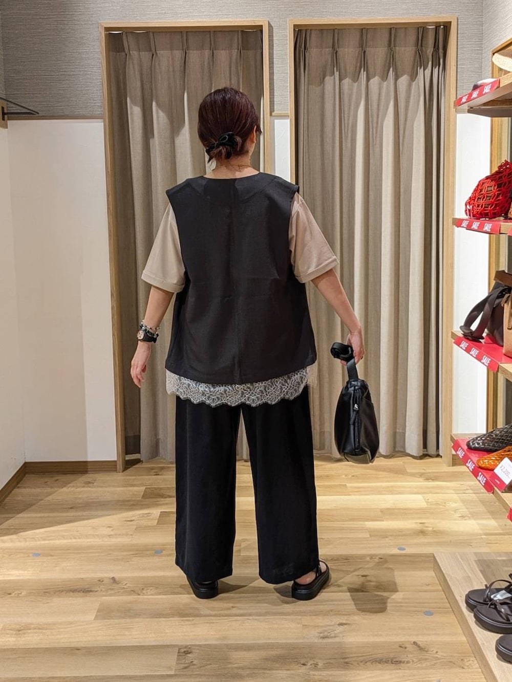 ブラウン系のサンダル、ブラック系のその他パンツ、ベージュ系のTシャツ/カットソーを着用したレディースの夏コーディネートの2枚目の写真