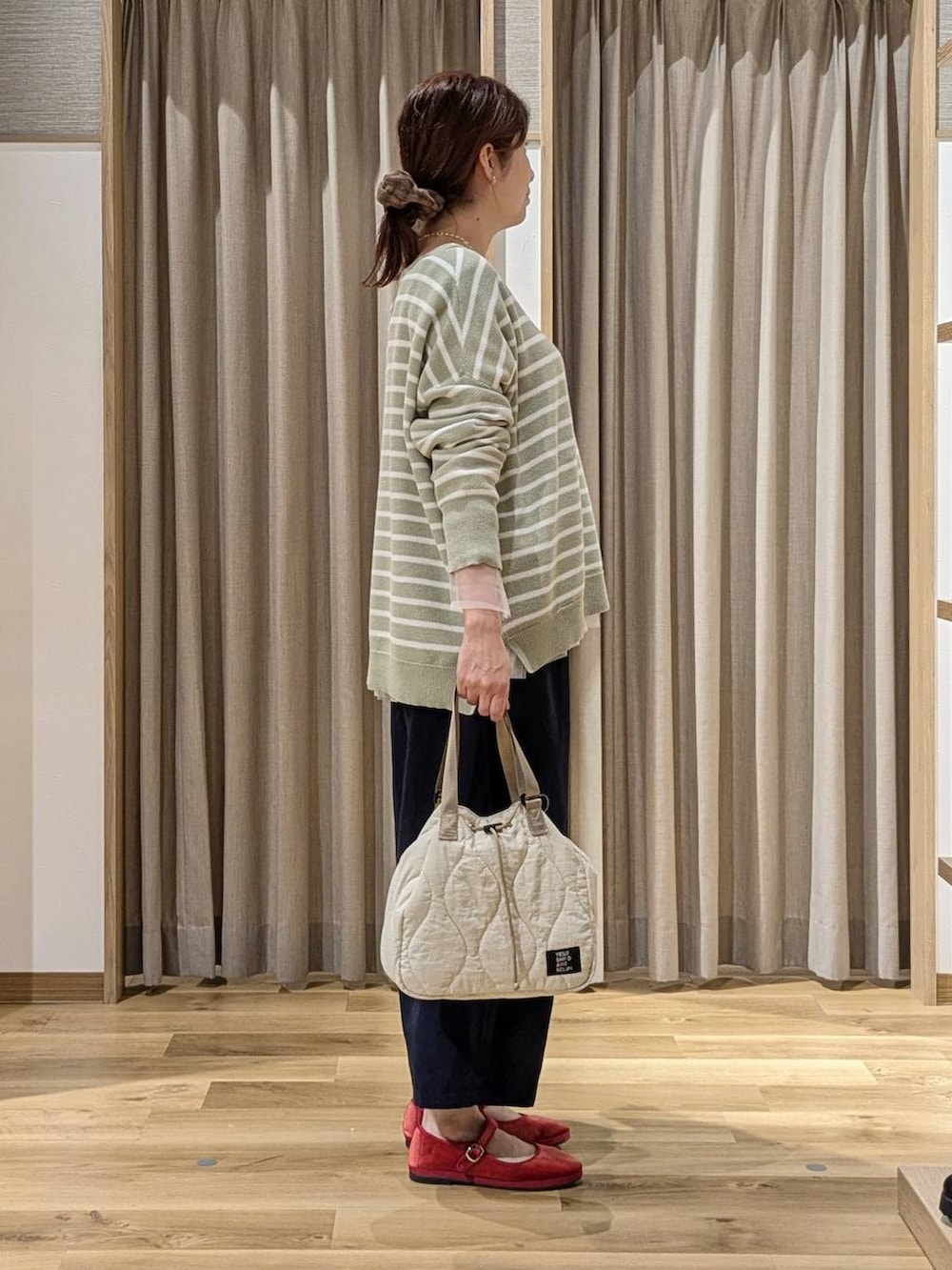 レッド系のその他シューズ、その他のTシャツ/カットソー、グリーン系のニット/セーターを着用したレディースの秋コーディネートの2枚目の写真