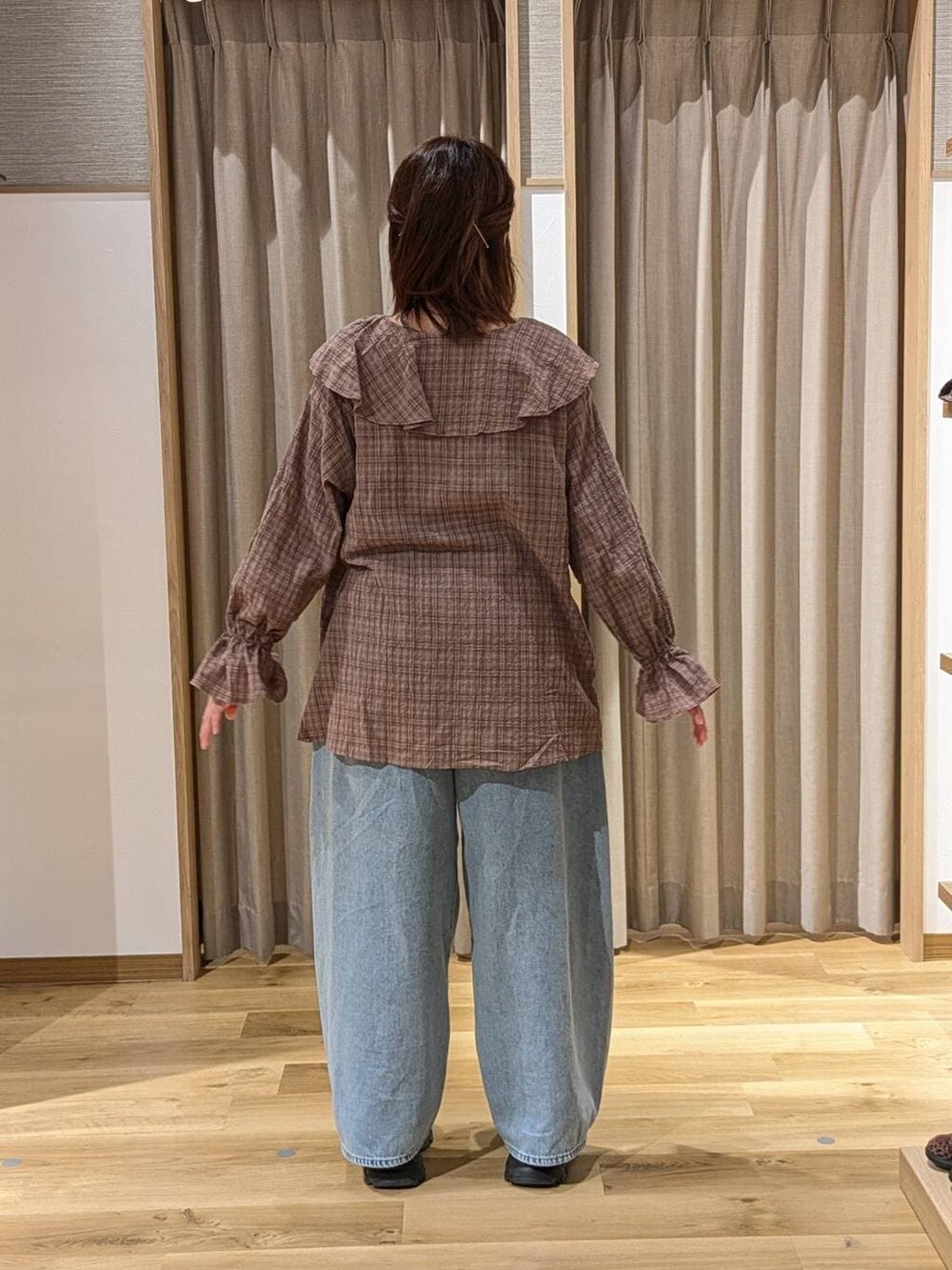 ブラック系のショルダーバッグ、ブルー系のデニムパンツ、ブラウン系のシャツ/ブラウスを着用したレディースの冬コーディネートの2枚目の写真