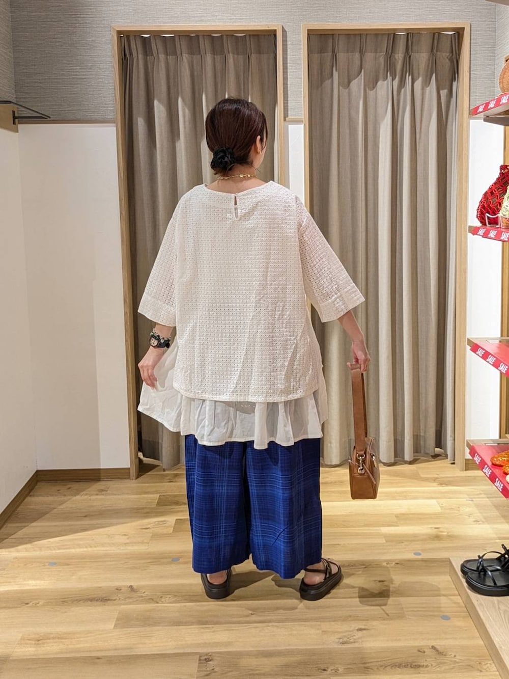 ブラウン系のショルダーバッグ、ブラウン系のサンダル、ブルー系のその他パンツを着用したレディースの夏コーディネートの2枚目の写真