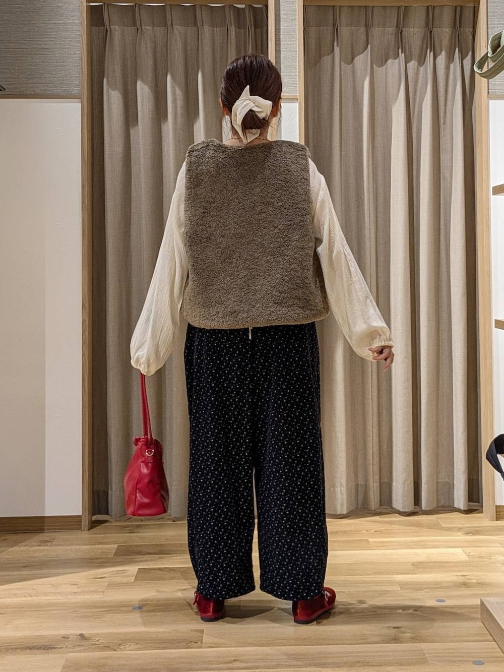 ブルー系のその他パンツ、レッド系のその他シューズ、レッド系のショルダーバッグを着用したレディースの秋コーディネートの3枚目の写真