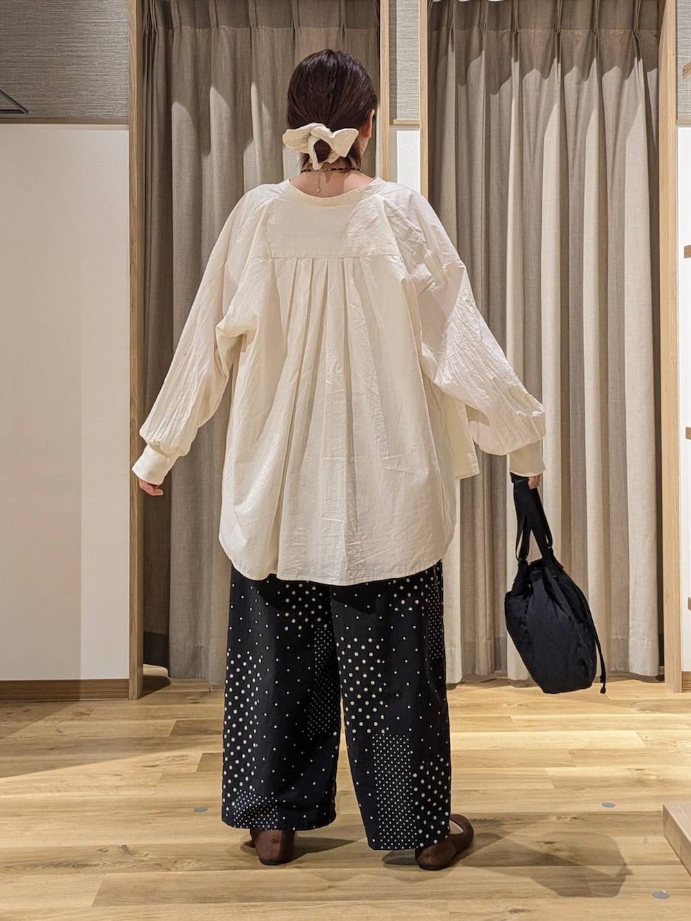ベージュ系のシャツ/ブラウス、ホワイト系のベスト、ブラック系のその他パンツを着用したレディースの秋コーディネートの3枚目の写真